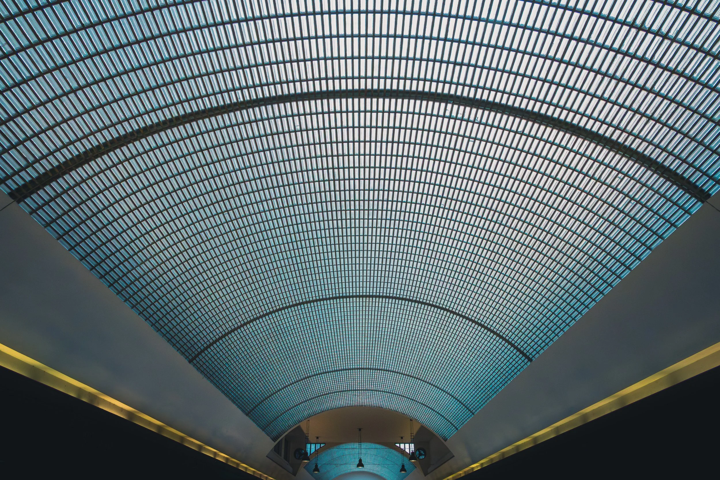 Curving glass ceiling inside the U Stýblů arcade in Prague above a narrow passage