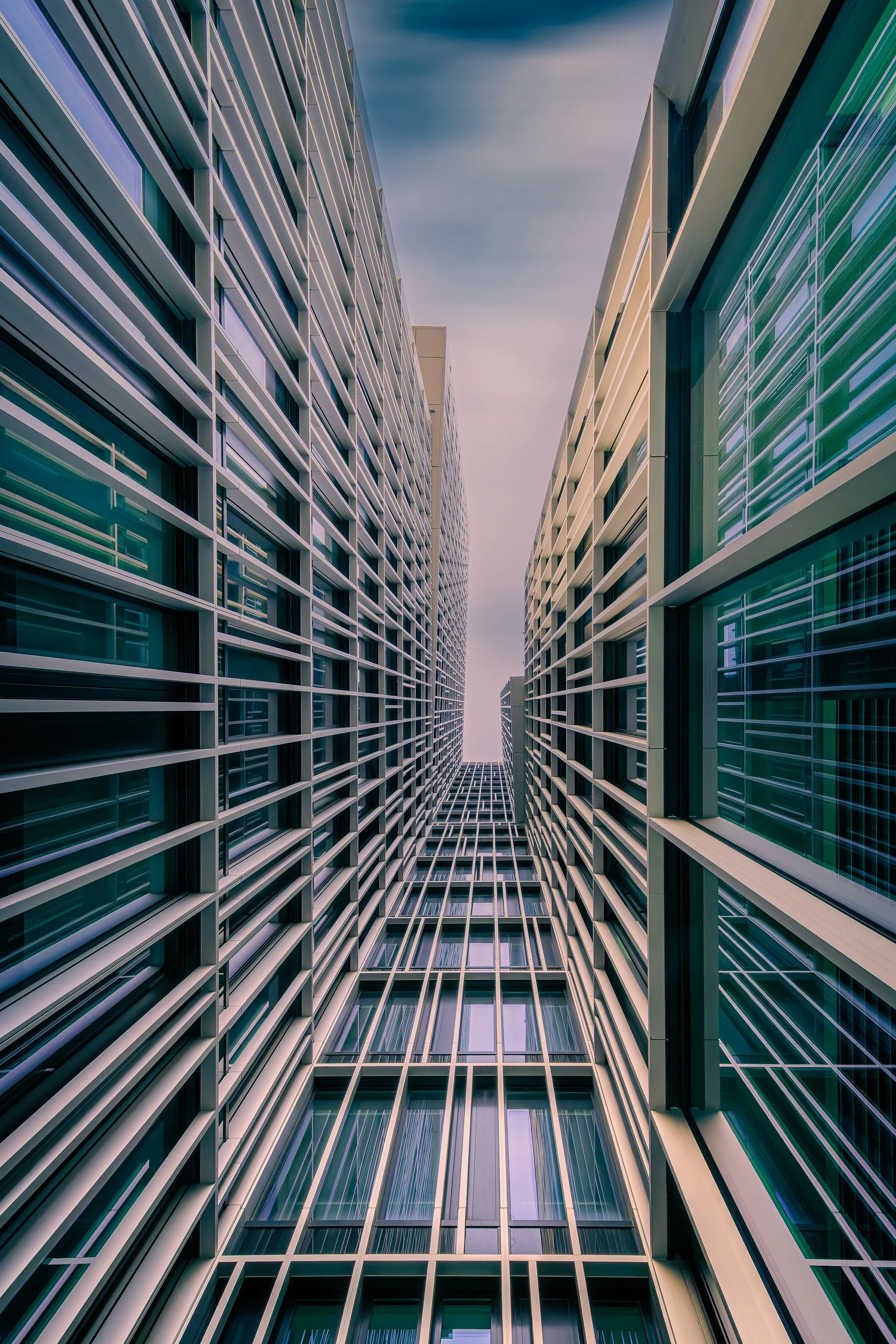 Upward view between modern glass facades with repeating horizontal lines