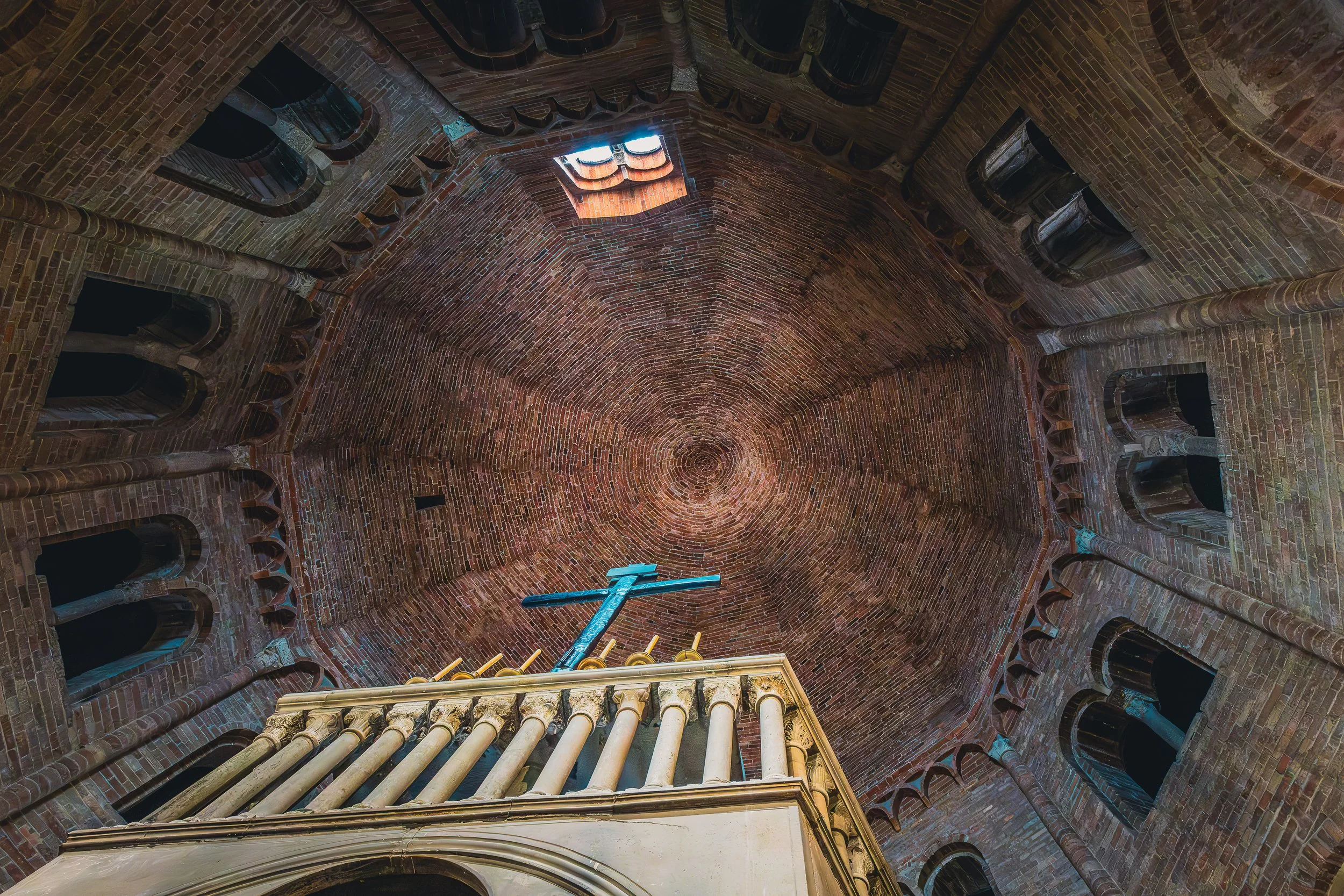Upward view inside the Basilica of Santo Stefano in Bologna with brick walls and an octagonal interior