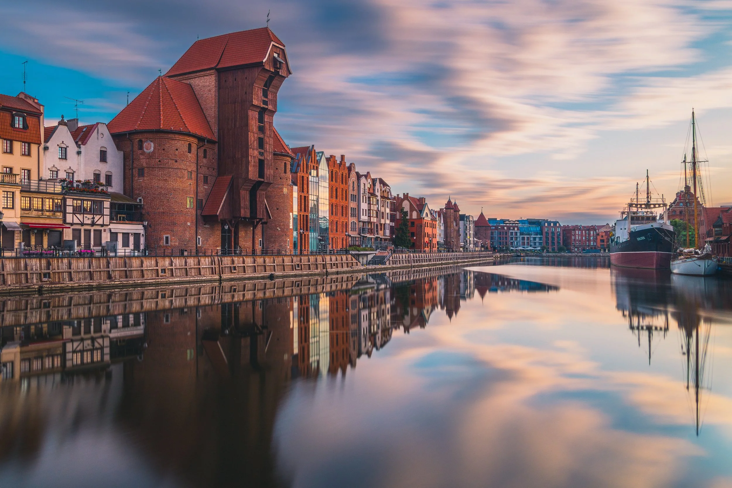 Historic waterfront buildings and the medieval Crane along the Motława River in Gdańsk.