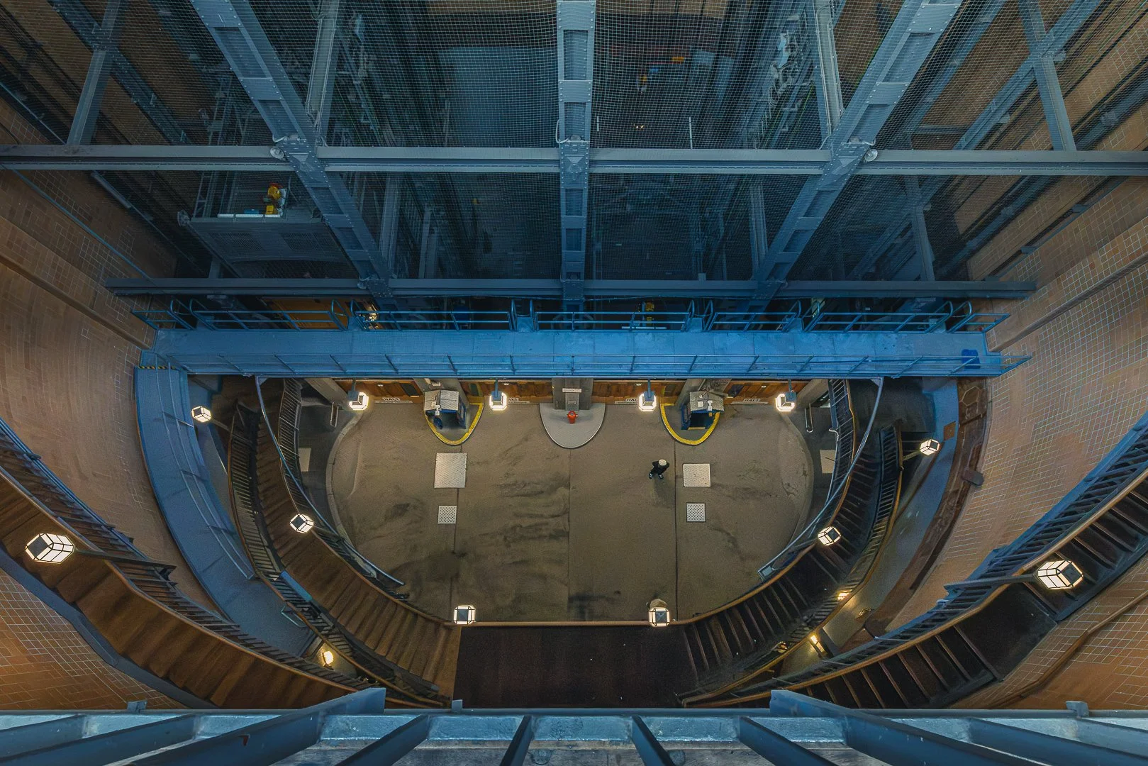 Symmetrical industrial interior in Hamburg with steel structures, stairways and warm lights creating a strong sense of depth.