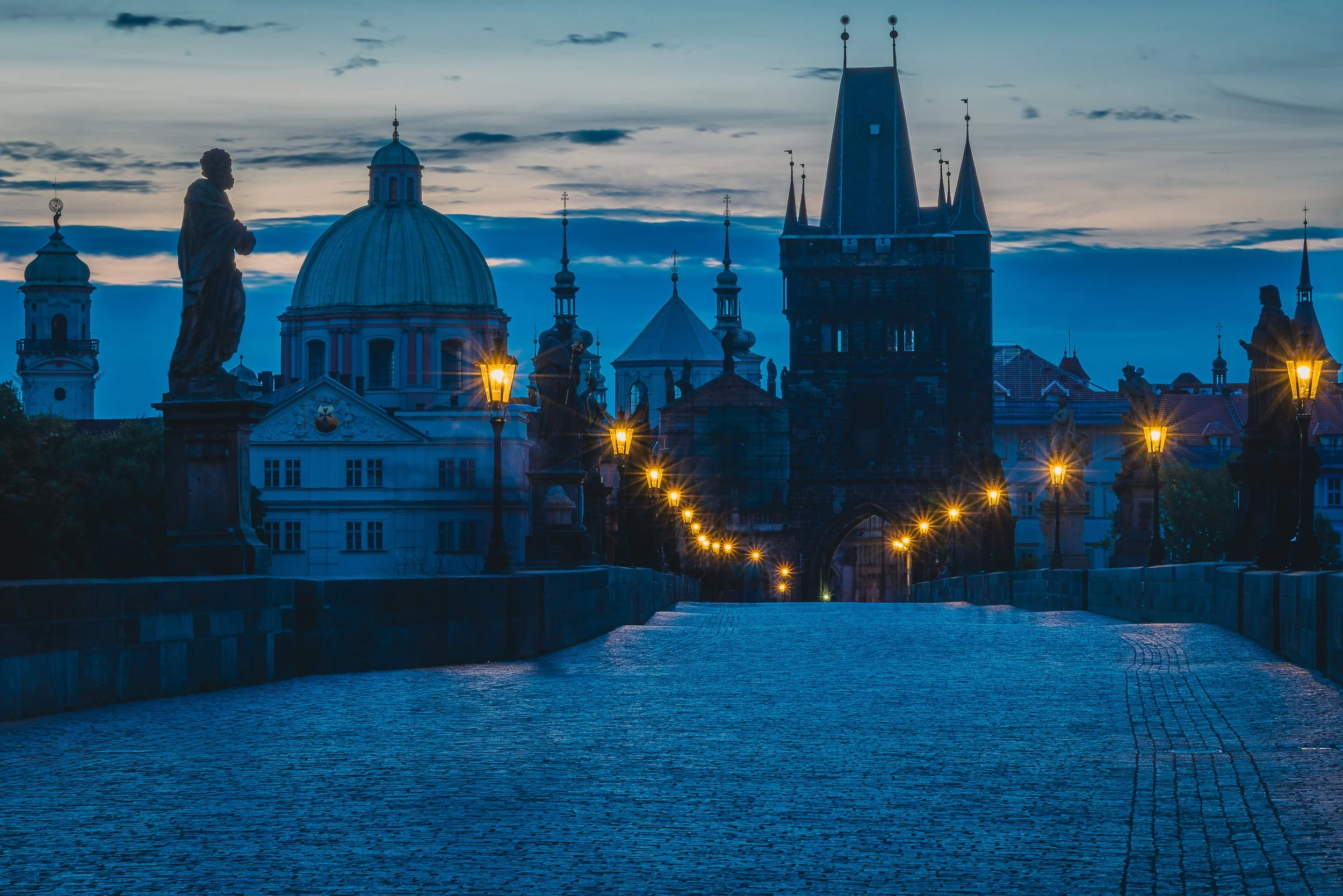 Empty Charles Bridge in Prague at blue hour with the Old Town towers in the distance
