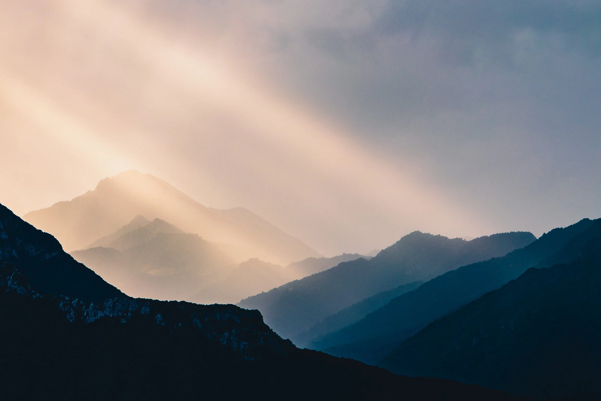 Layered mountain ridges at Lake Garda illuminated by soft rays of light