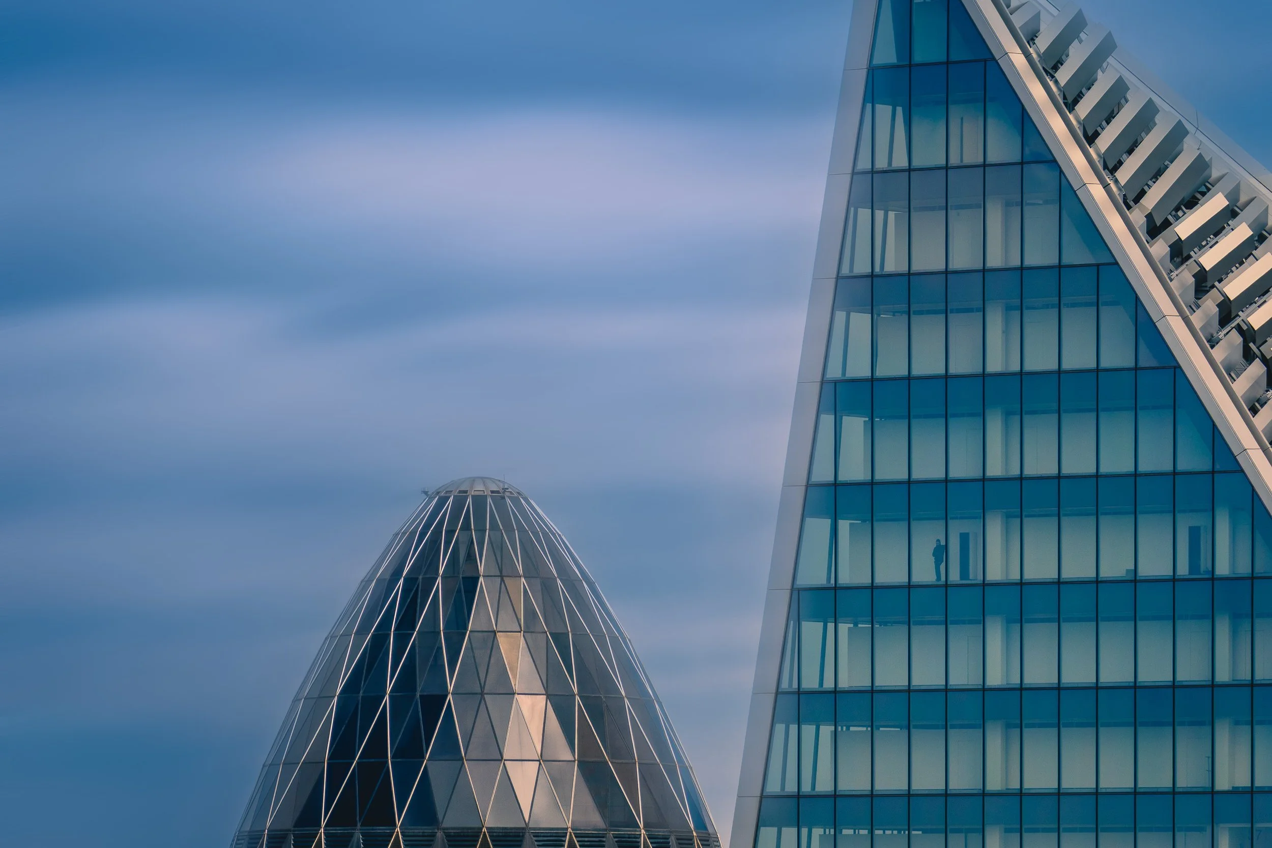 Modern London skyscrapers rising against a soft blue sky