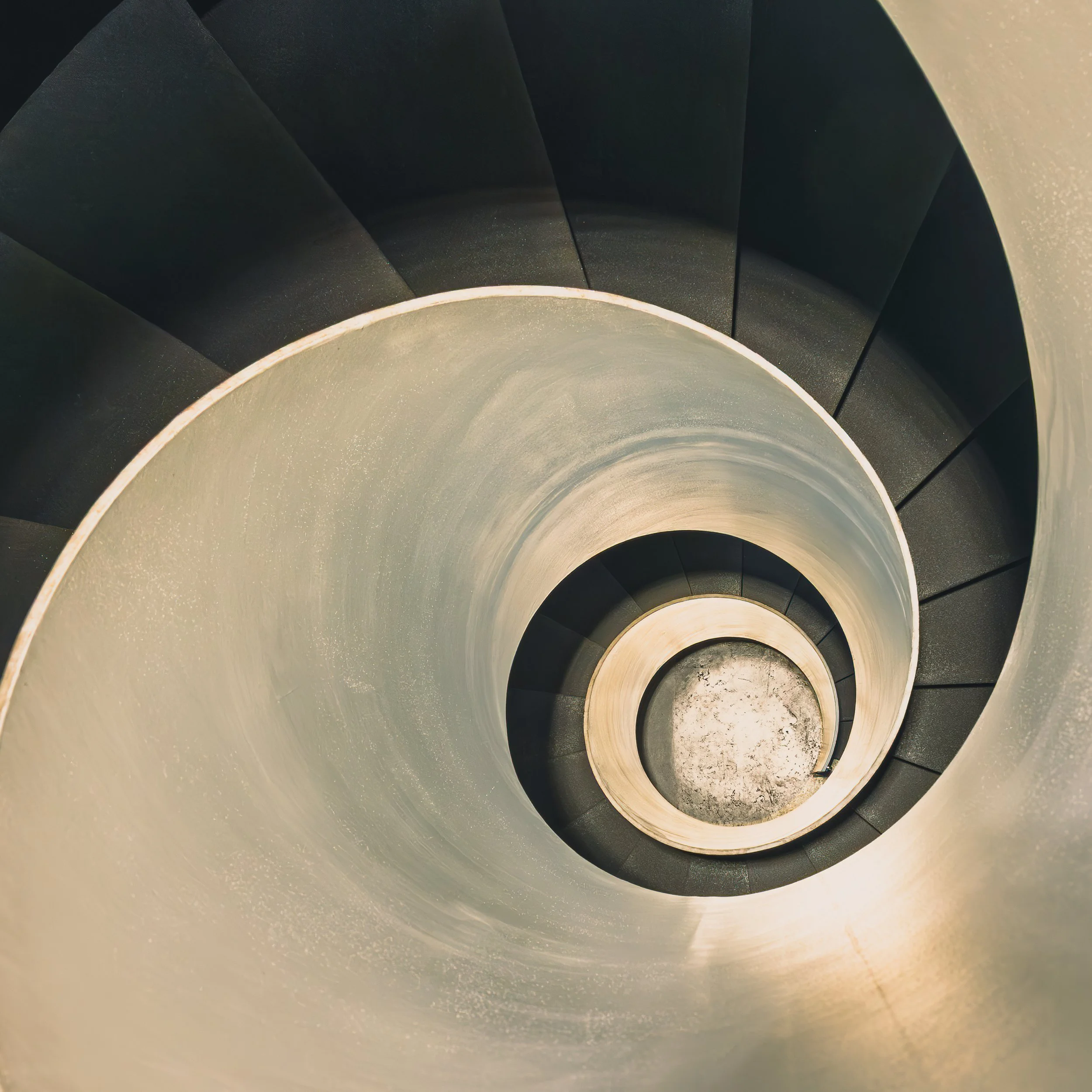 Spiral staircase viewed from above as a tight black and white curve