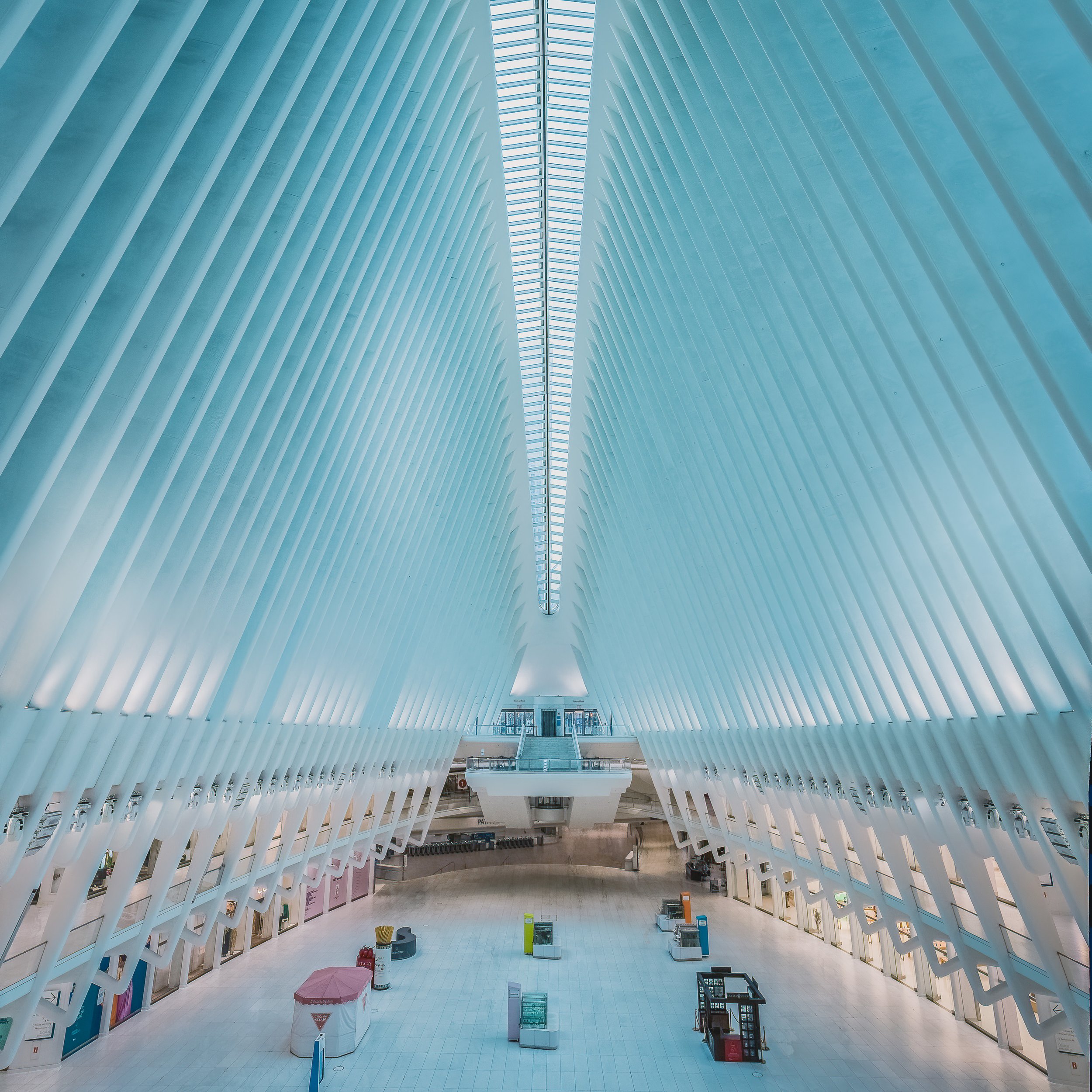 Symmetrical white interior of the Oculus in New York with sweeping ribbed architecture