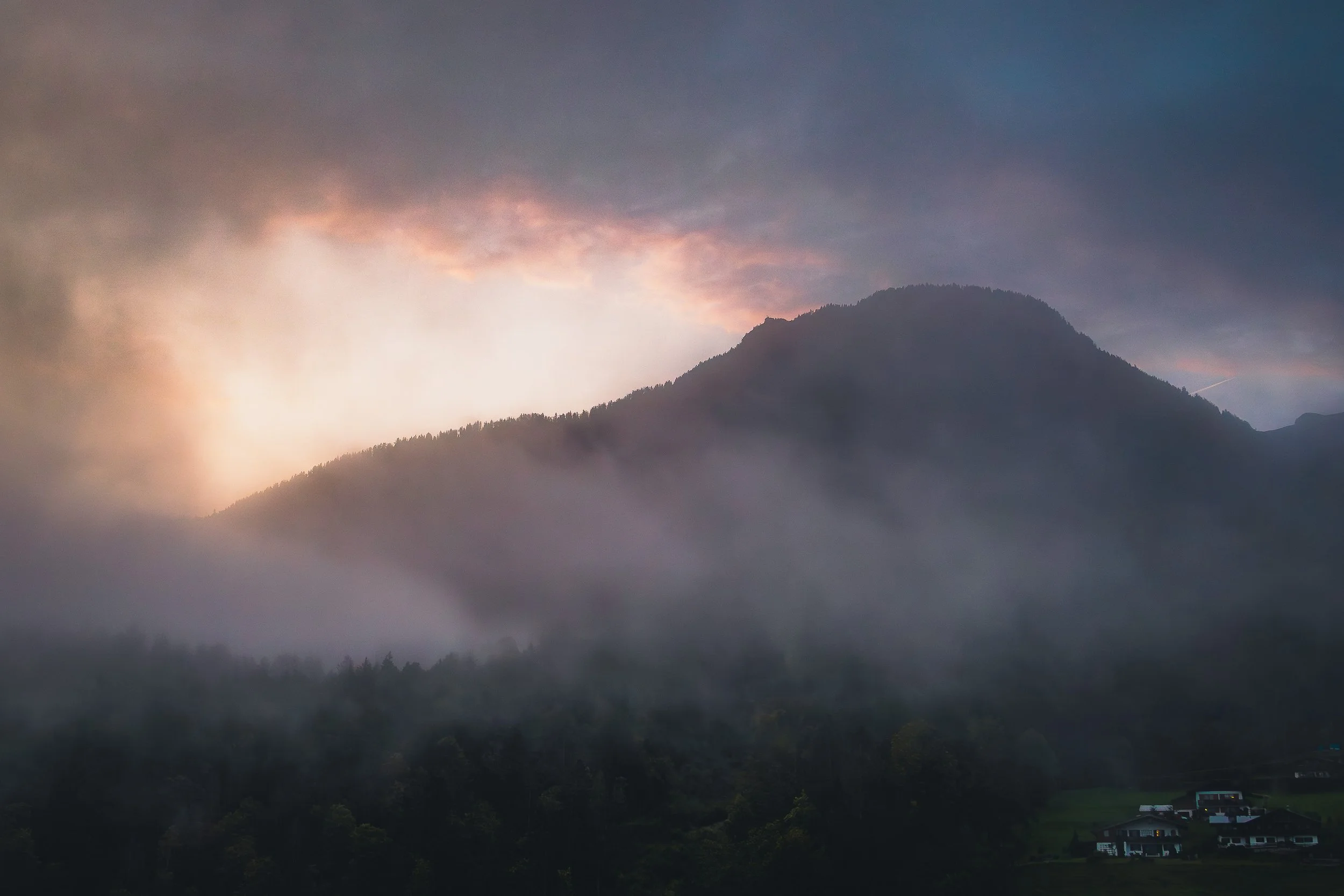 Mountain emerging through low fog beneath soft evening light in Berchtesgaden
