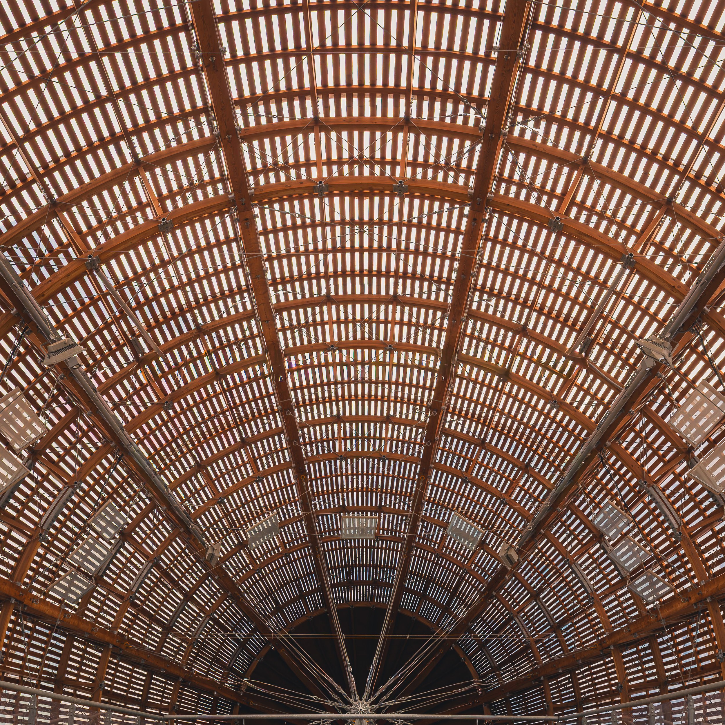 Curved wooden lattice structure forming a repeating pattern at DOX in Prague