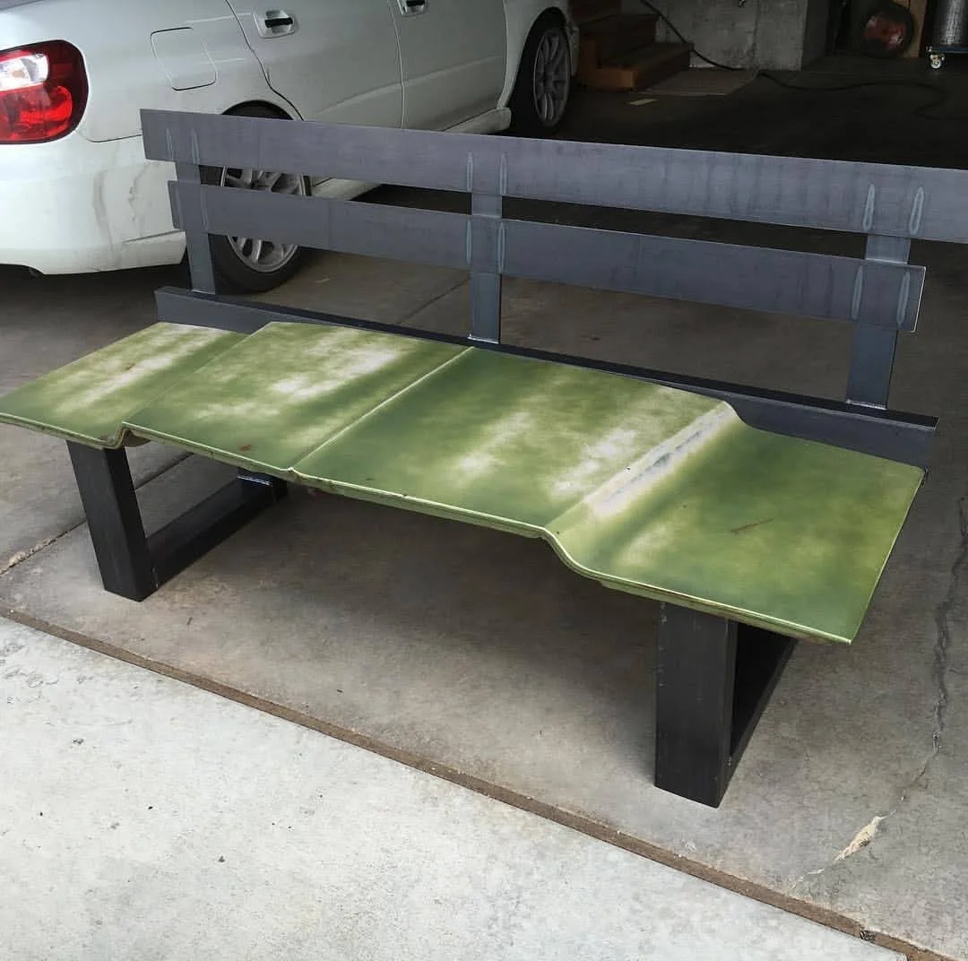 Re-purposed car hood with green patina and a metal back. Square metal base. 
