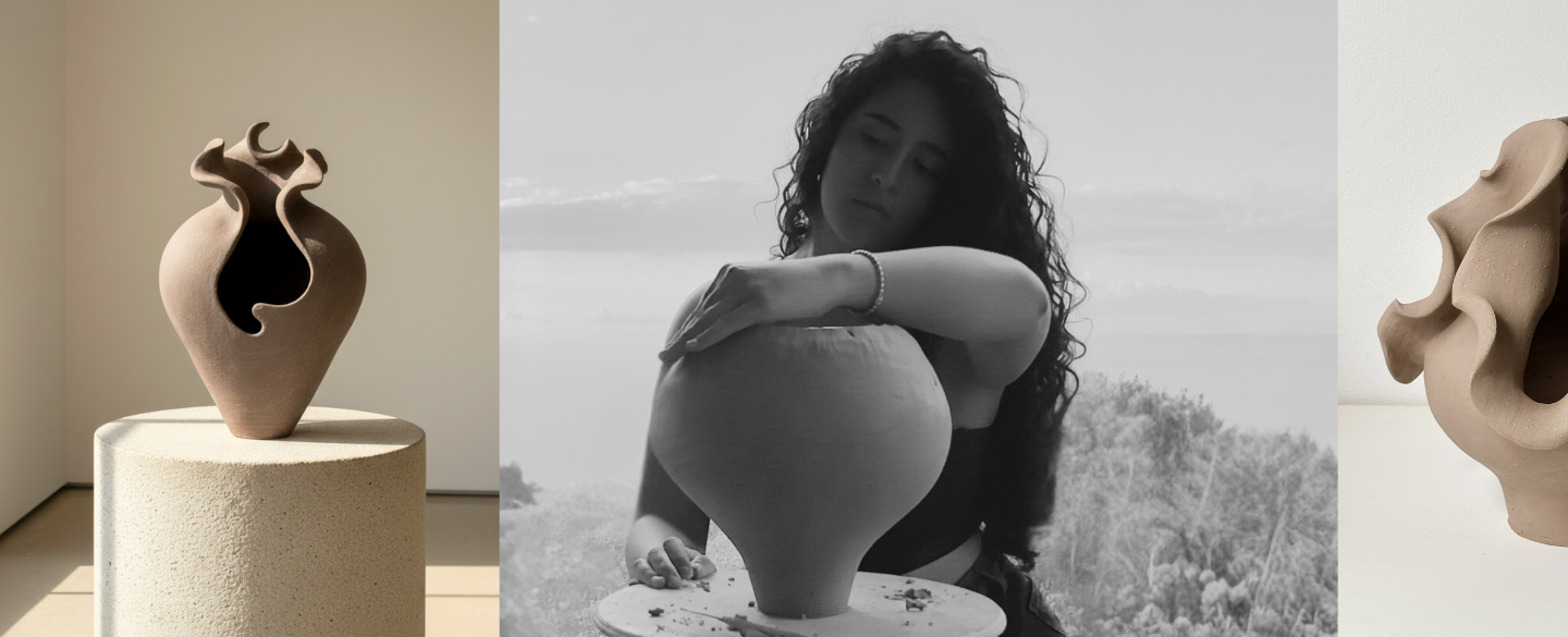 Black-and-white photograph of a woman with curly hair hand building a large pottery vase outdoors, with a background of trees and sky.
