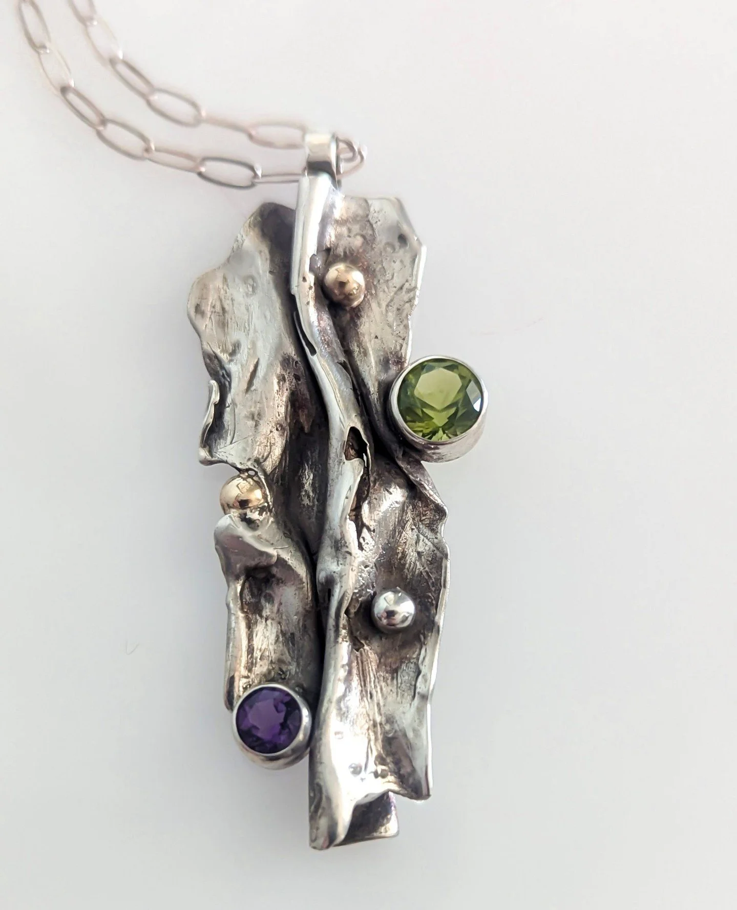 This intricate crinkle pendant by Crazy Hair Susan ⁠is making us want to visit the beach and comb for treasures 🌅⁠
⁠
Made with sterling silver, 14k yellow gold, peridot, amethyst.