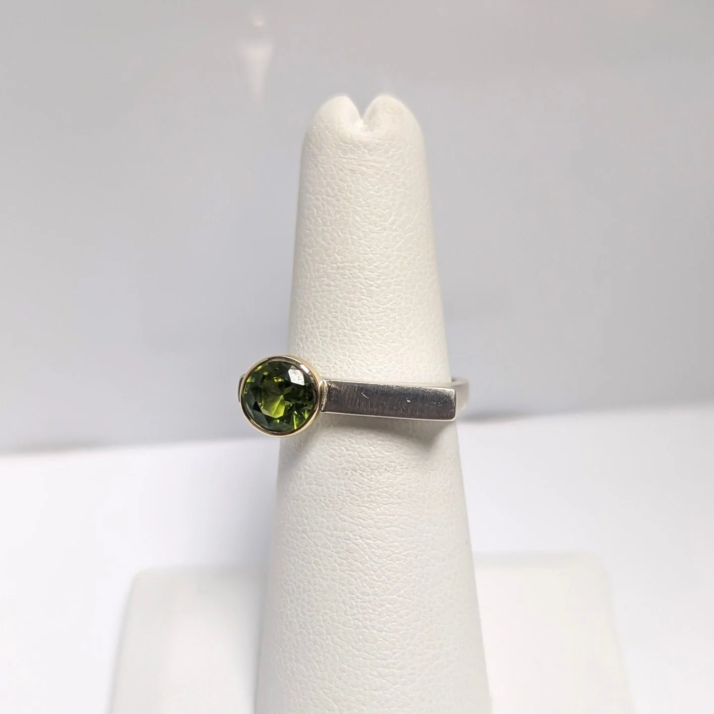 The birthstone for August is peridot: made from the mineral olivine, this stone so aptly has a lime to olive green coloration. Egyptians called this the "gem of the sun" 🌄⁠
⁠
Stacker ring (sterling silver, 14k gold, peridot) by Bill Wismar