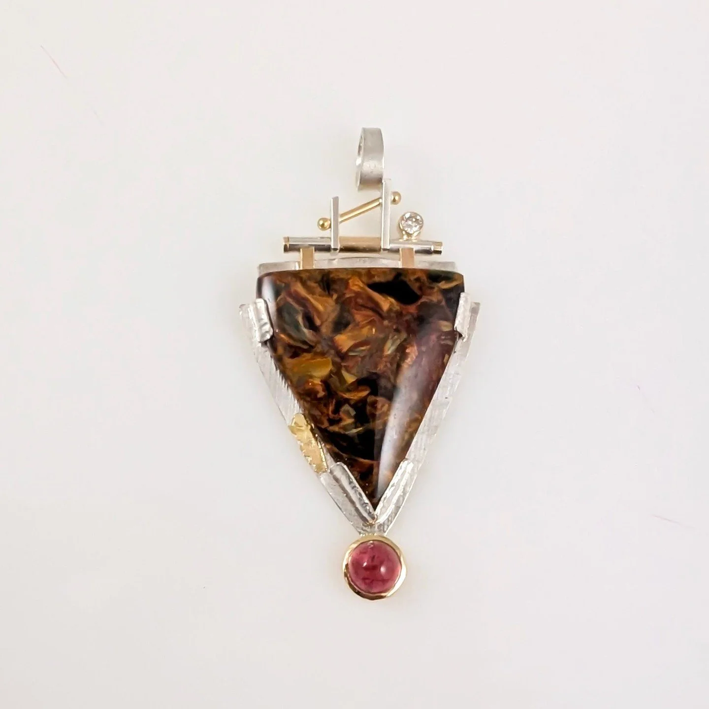 ⁠The balance between simplicity and complexity in this piece is truly art!⁠
Pendant with sterling silver, 18k, 22k, jasper, pink tourmaline, and .06ct diamond by Bill Wismar Designs.