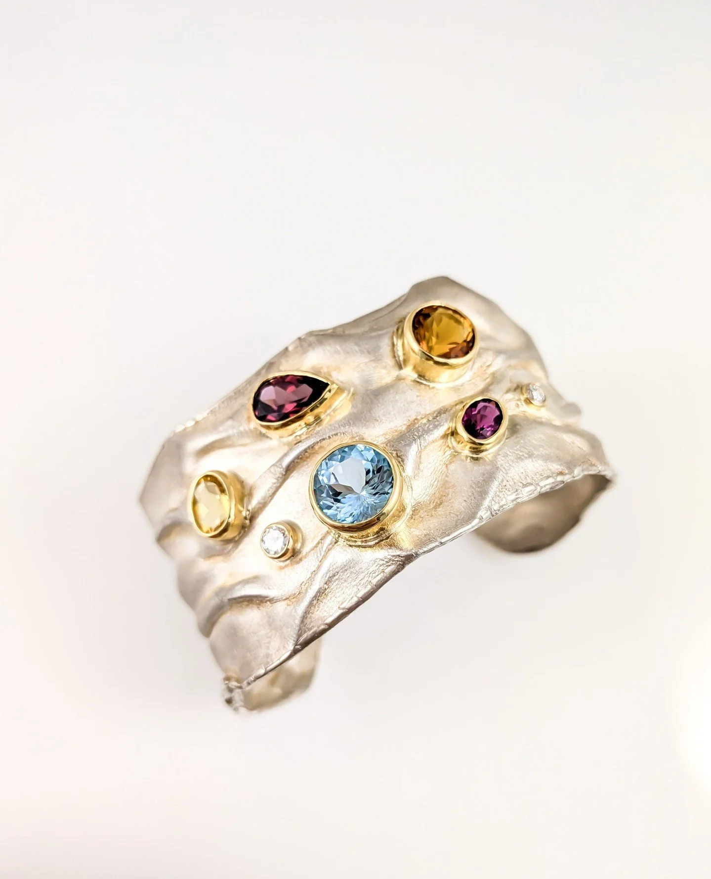 There are various gemstones in this piece including tourmaline, one of October's birthstones! This glittering sterling silver cuff with 14k by Bill Wismar reminds us of the gorgeous sunsets on the bay. Lovely to both in featured in the most recent is