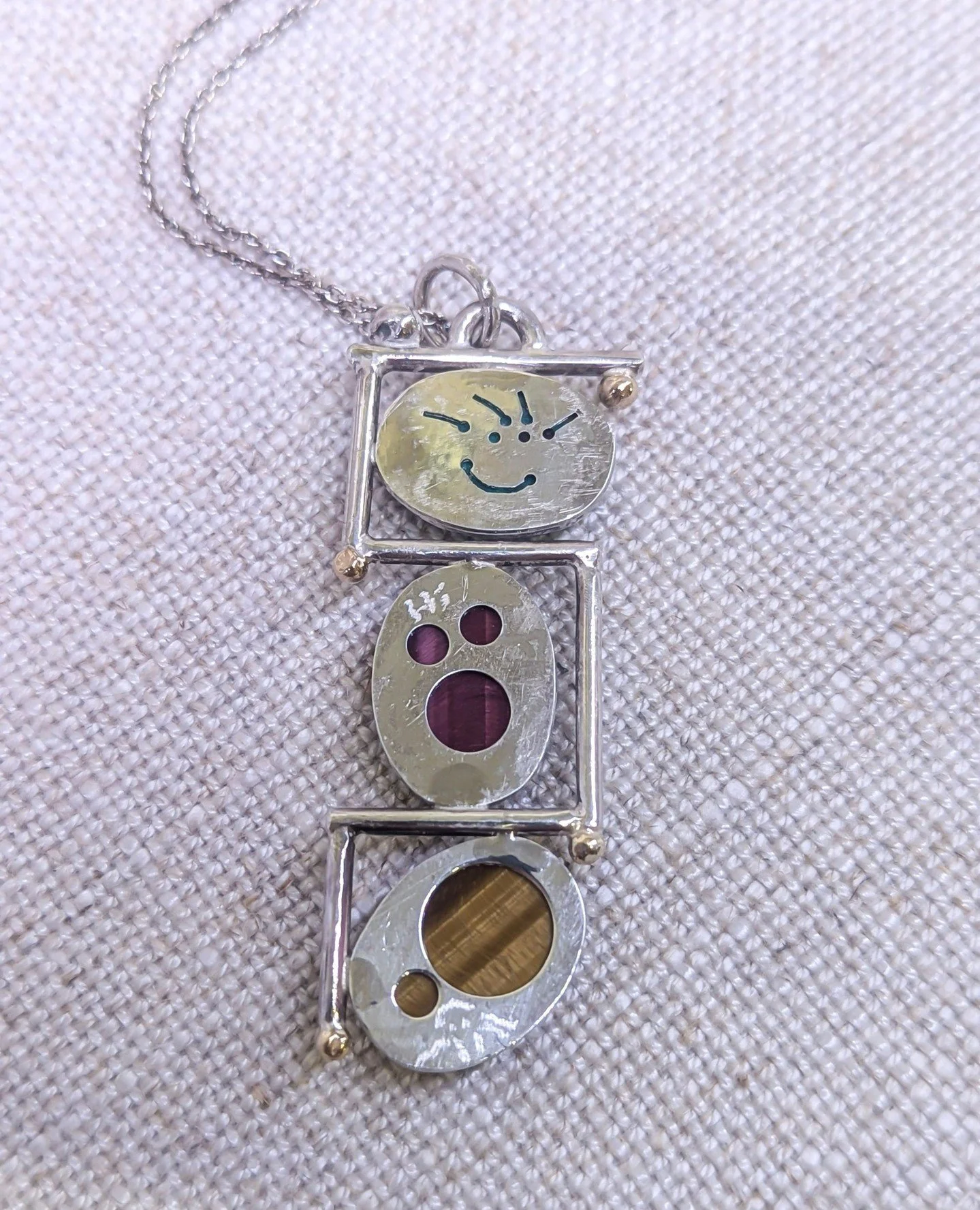 Susan Wismar's jewelry almost always has a fun surprise for the wearer on the back. Her work will surely put a smile on your face with her hidden messages and "Crazy Hair Designs" signature. Come take a look at what secrets we have in store