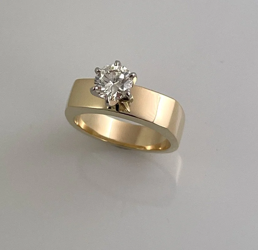 Gold ring with a large diamond solitaire on a light background. Design by Bill Wismar. Perfect for an engagement.