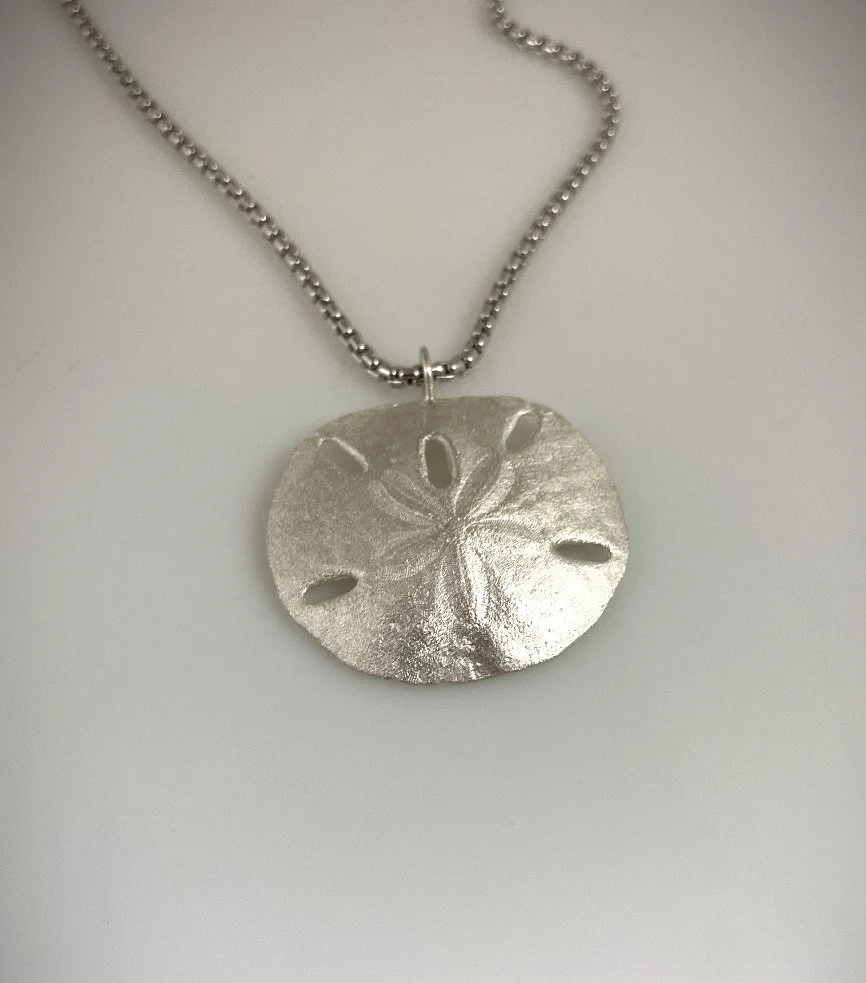 High polish sterling silver necklace pendant featuring sand dollar design.