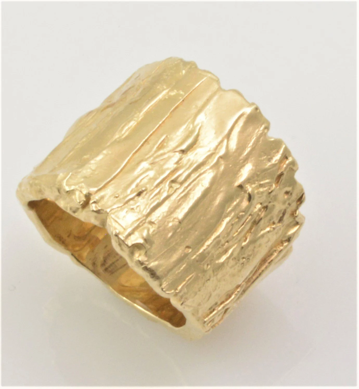 A gold wood textured ring designed by Bill Wismar.