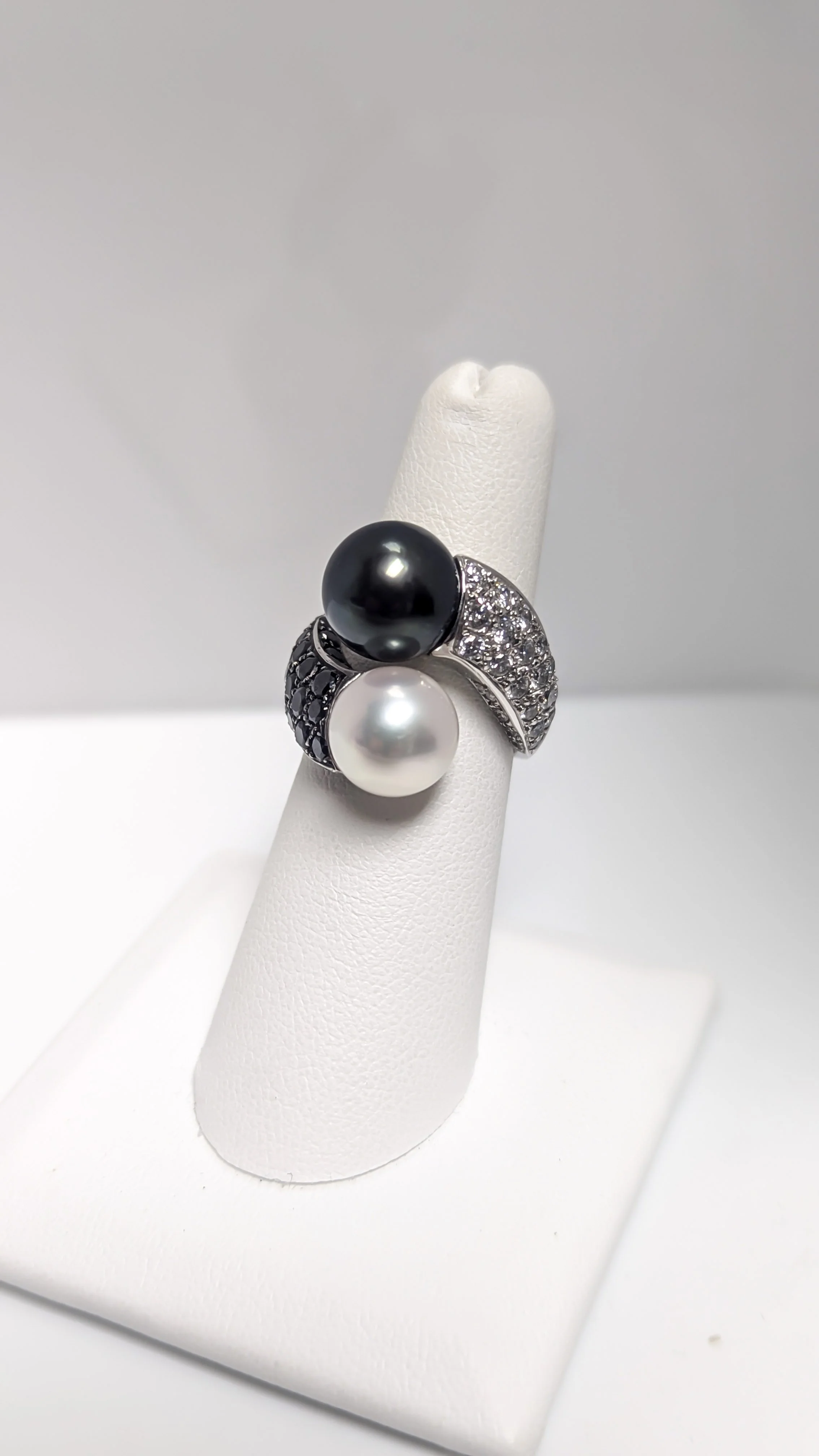 Silver ring with two large pearls, one black and one white, and encrusted with small diamonds, design by Rock Hard Design House.