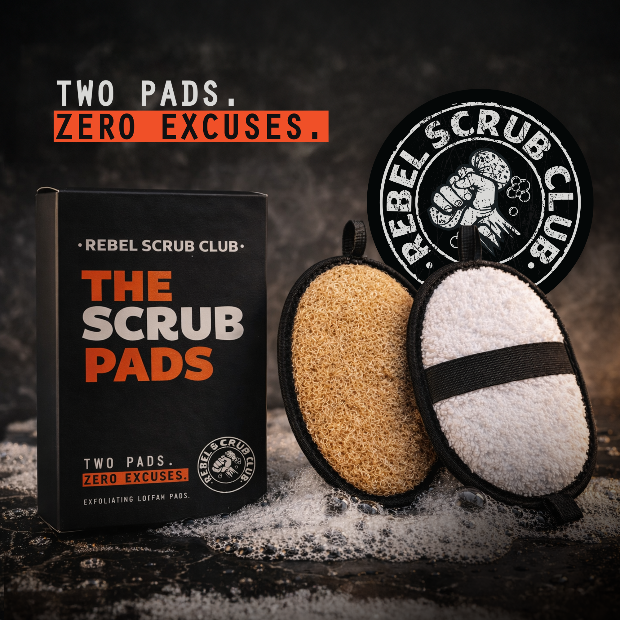 A box of Rebel Scrub Club exfoliating loofah pads with two pads, one beige and one white, placed in front of a Rebel Scrub Club logo. The scene is set on a dark surface with soap suds scattered around.