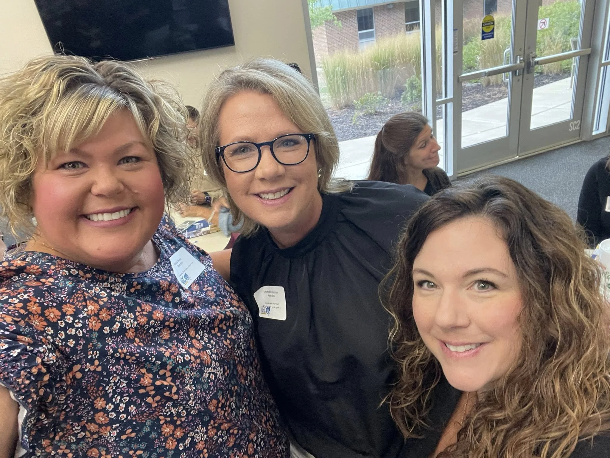 Women in leadership members taking a selfie at event.