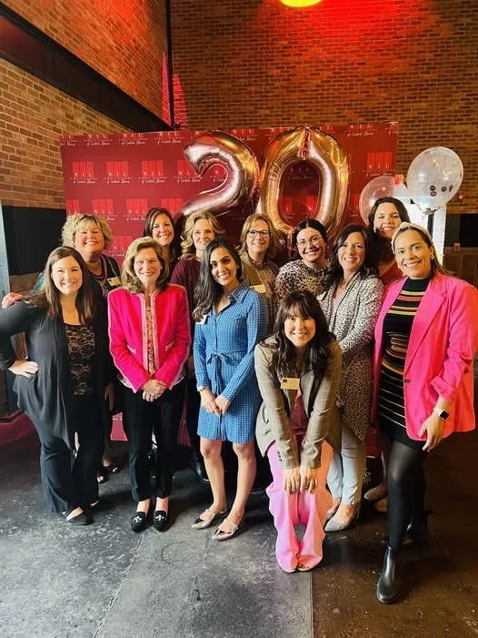 Women in leadership members celebrating at event.