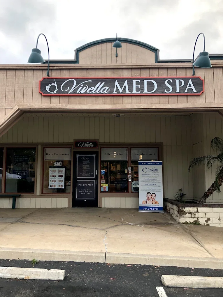 Front view of Vidella Med Spa storefront with signage, window advertisements, and a sidewalk outside.