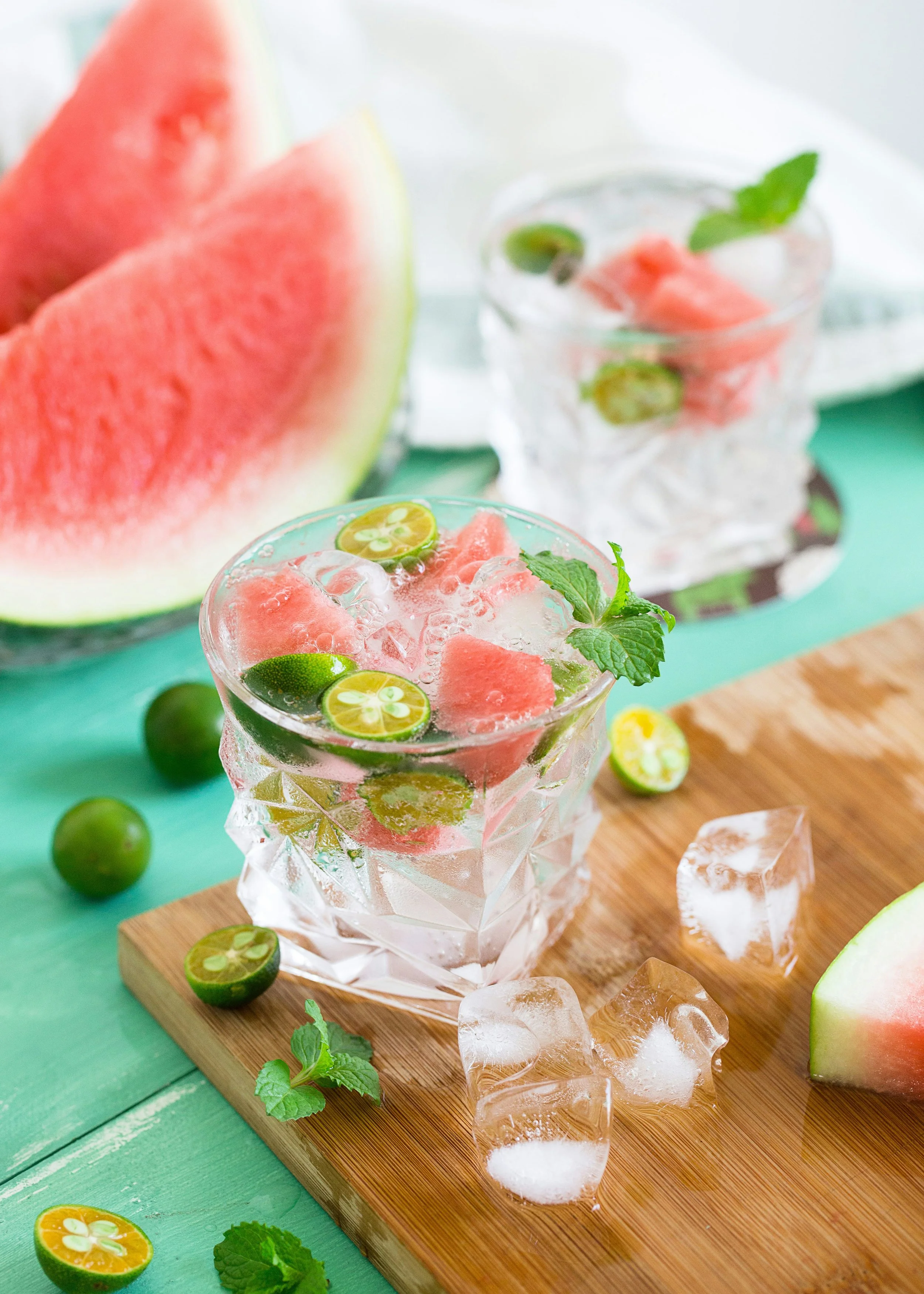 Solo cup bartender displaying two glasses of watermelon and lime infused water with ice, mint leaves, and sliced lime and watermelon in Salt Lake City, Utah.