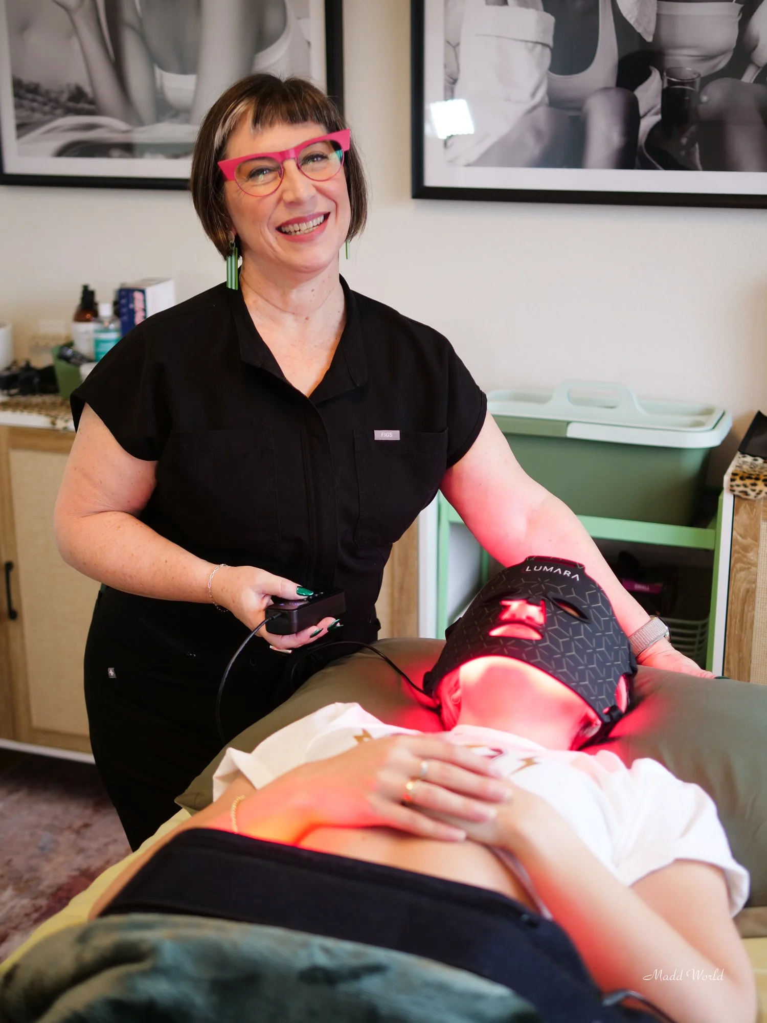 Danielle smiling at camera while working on clients facial treatment