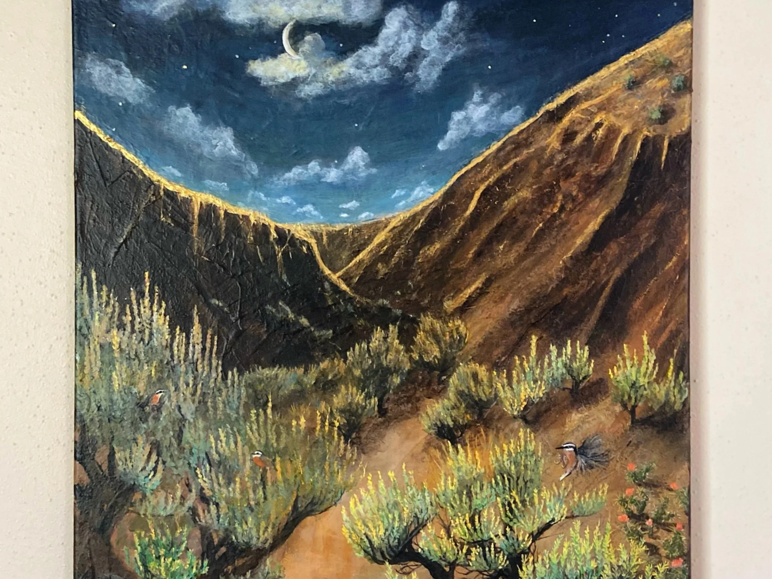 A painting of a desert landscape at night with a crescent moon and stars in a dark sky, surrounded by mountains, green bushes, and a few small birds.