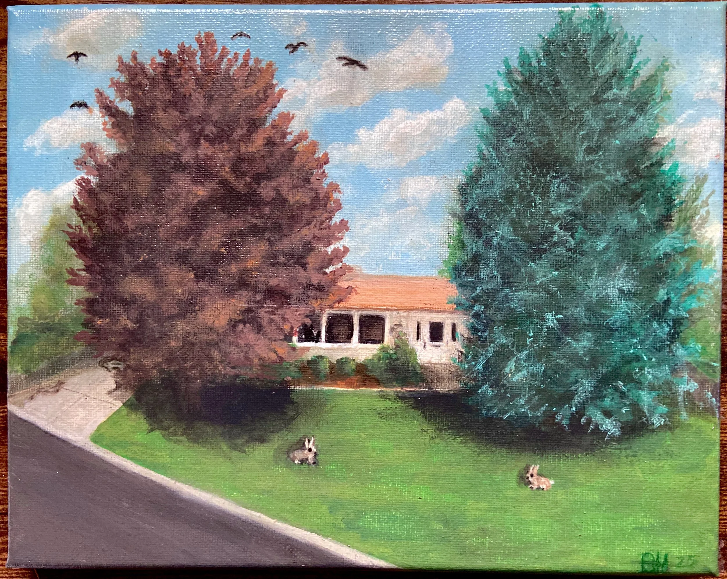 A painting of a house partially visible behind two large trees, one with reddish-brown leaves and the other with green leaves. There is a grassy yard with two rabbits and a sidewalk beside a street. The sky is mostly cloudy with a few birds flying ov