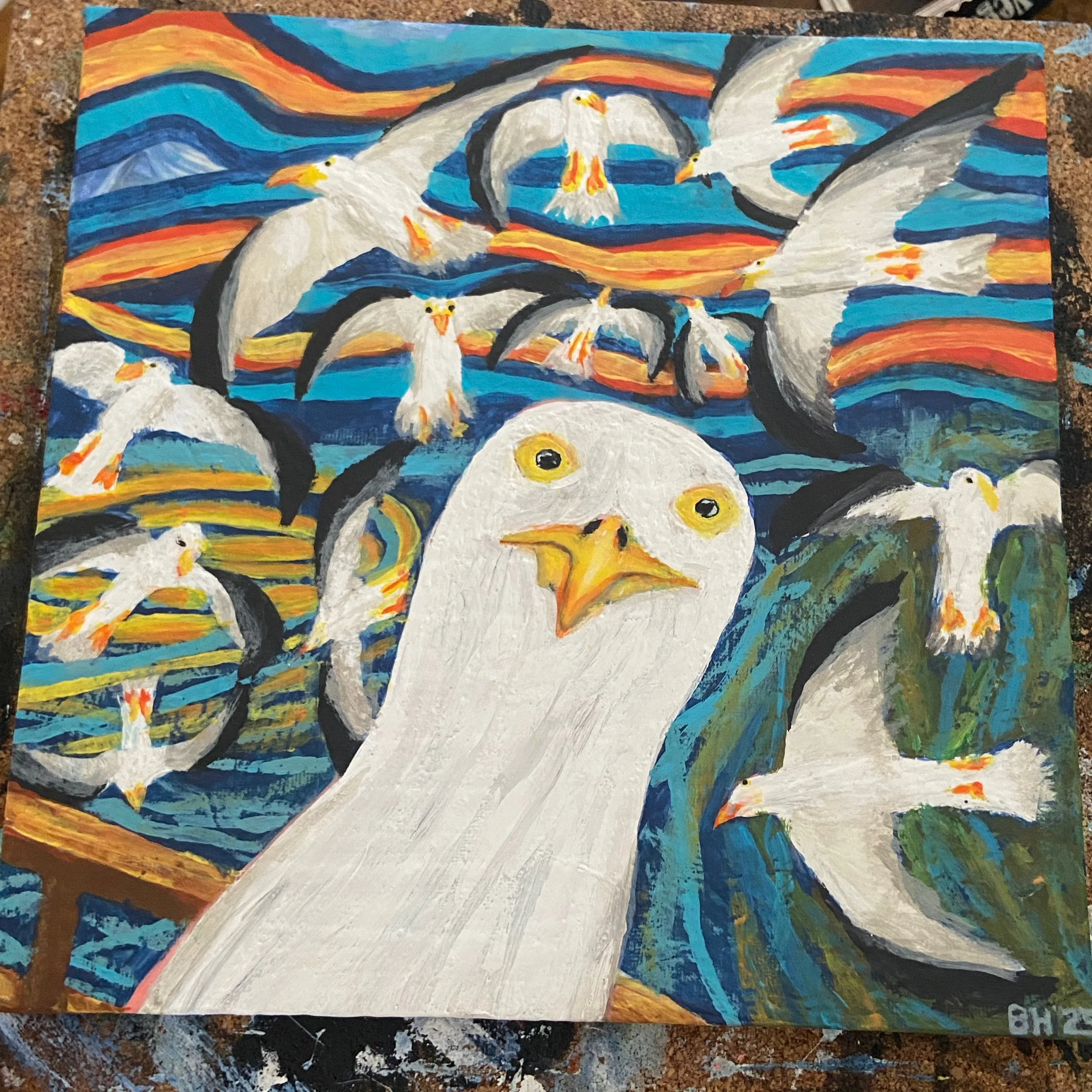 A vibrant painting of multiple seagulls flying in a colorful sky with hues of blue, orange, and red, featuring one large seagull prominently in the foreground.