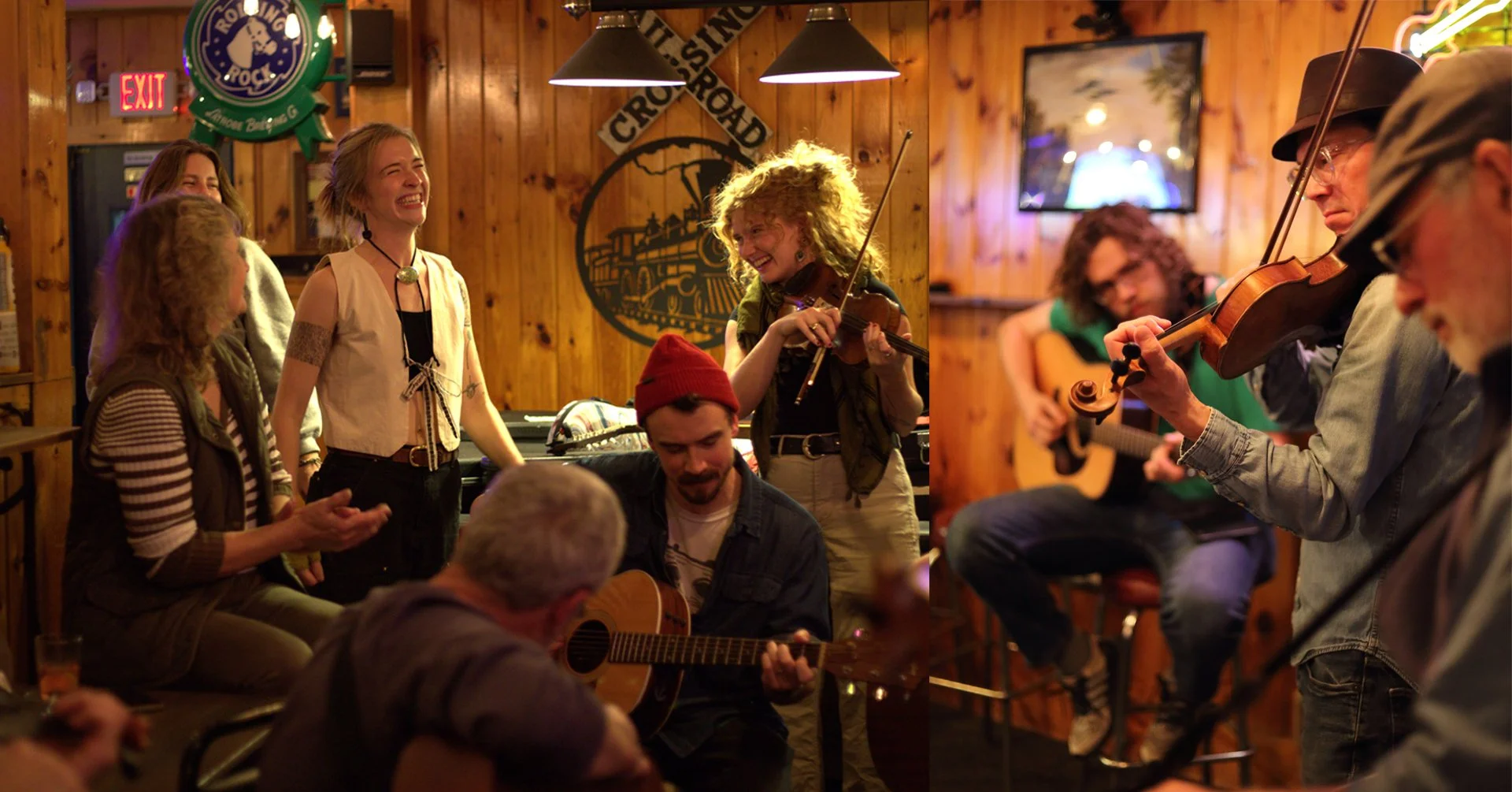 A group of people enjoying live music in a cozy, wood-paneled bar or restaurant. Some are playing instruments like violin and guitar, while others are singing or watching the performance. The atmosphere is lively and cheerful.