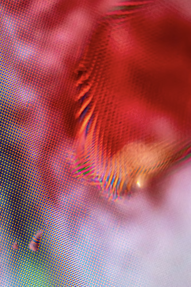 Close-up of a colorful digital screen displaying a red, pink, and purple abstract pattern with pixelation.