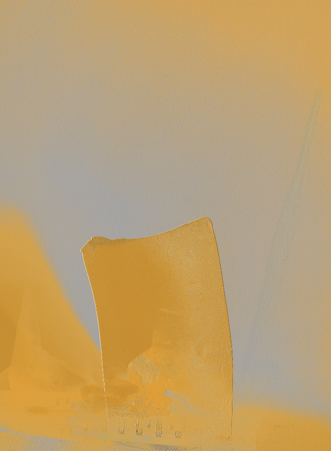 Close-up of a glass of orange juice with a large orange wedge on a white surface against a yellow background.