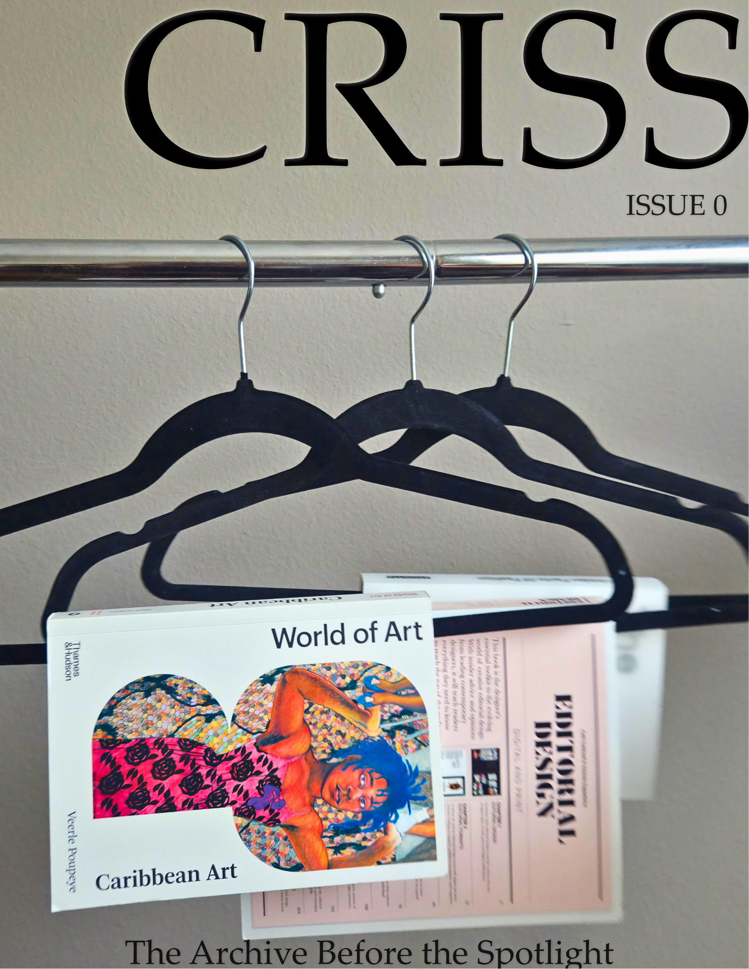Close-up of a magazine titled 'Crisis' Issue 0 on a wall, with black hangers and books below, including one titled 'World of Art' with a vibrant Caribbean art cover featuring a woman with blue hair.