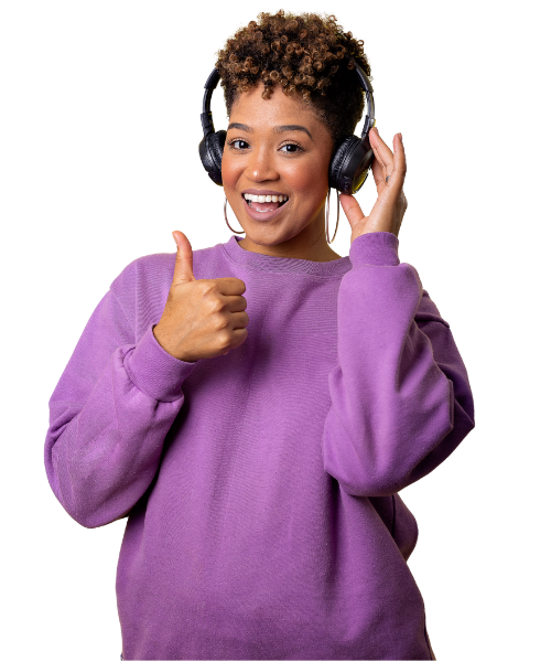 A young woman with short curly hair wearing headphones and a purple sweatshirt, smiling, giving a thumbs-up gesture.