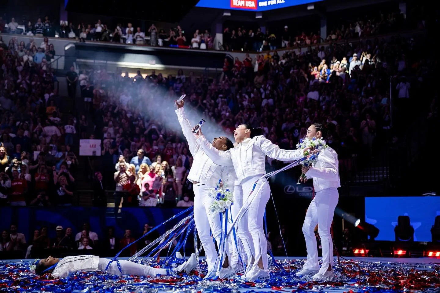Simone Biles, Jade Carey, and Sunisa Lee celebrate on the floor after being named to the 2024 U.S. Olympic Women's Gymnastics Team at the Olympic Trials. Photograph by Allison Mott.