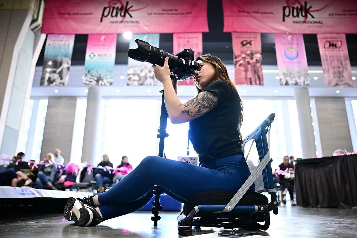 Gymnastics photographer Allison Mott capturing action shots at the Pink Invitational in Philadelphia, the largest breast cancer fundraising gymnastics competition in the US.