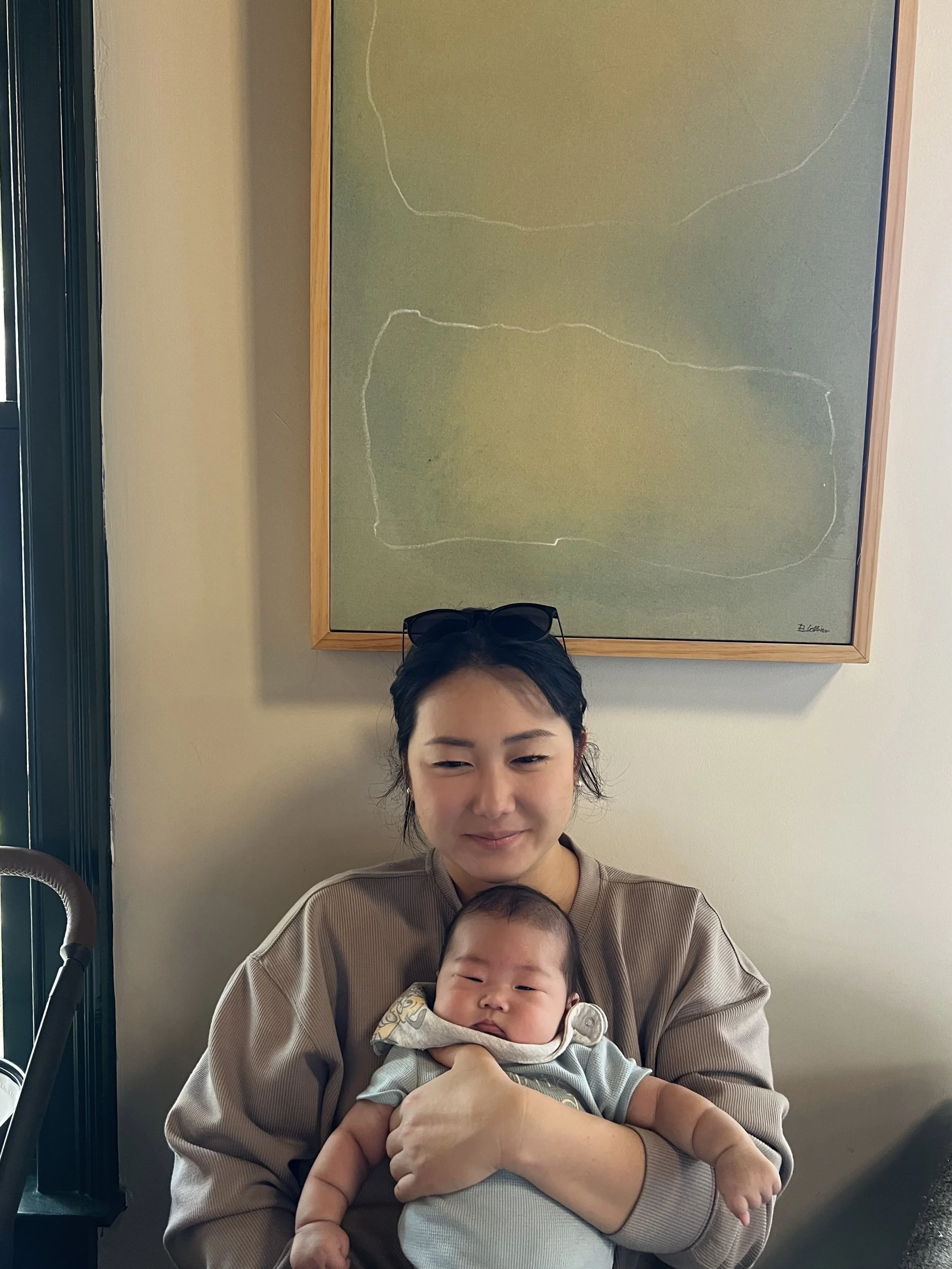 Founder holding her toddler in a calm, clean home—reflecting real life and the need for support