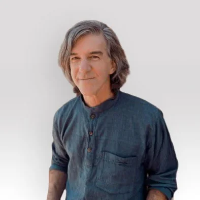 Portrait of a middle-aged man with gray hair wearing a dark blue shirt, smiling slightly, against a plain white background.