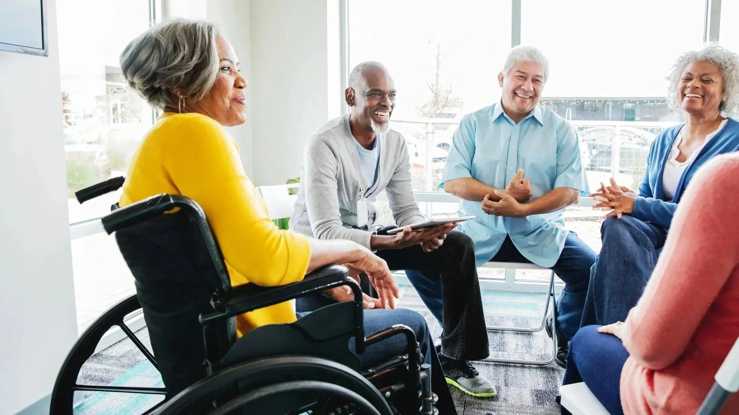 Older adults participating in a supportive community conversation during a social engagement gathering hosted by Up Giving Village.