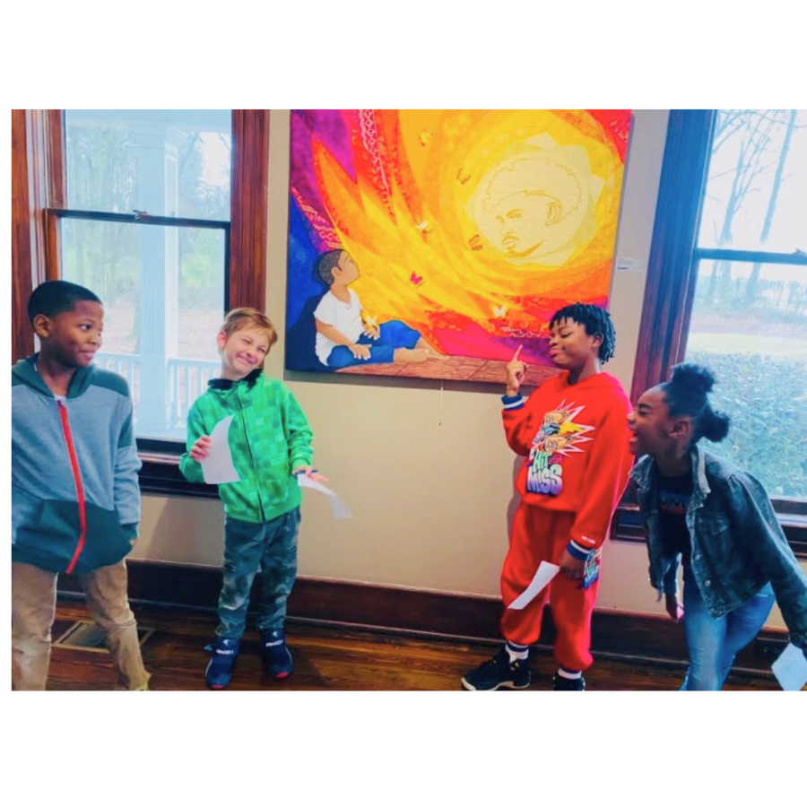 Children participating in a creative group activity that encourages expression, inclusion, and community connection,  in front of a colorful painting of a girl sitting by a fiery sun with a face, inside a room with wooden floors and large windows.