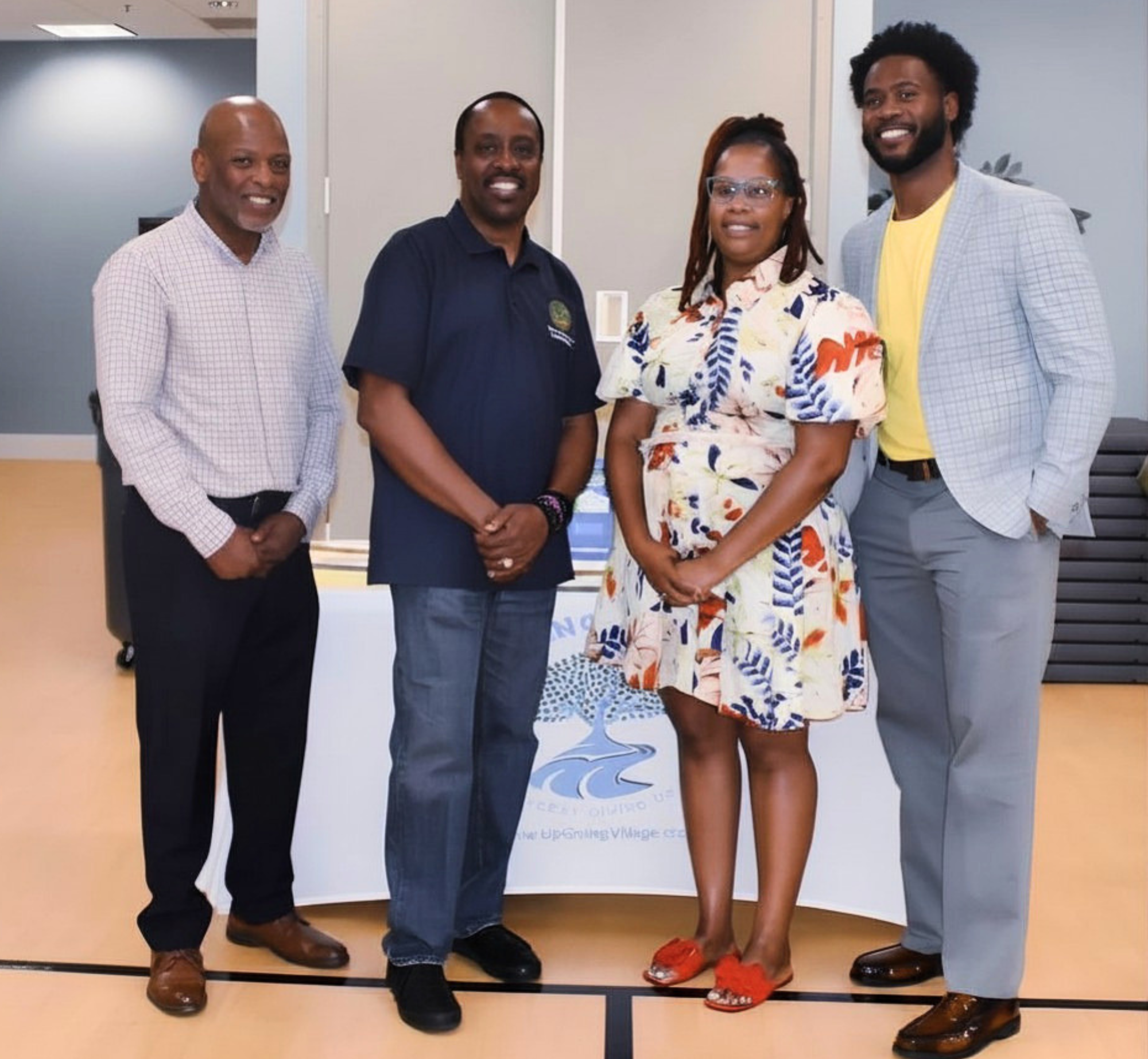 Up Giving Village board members gathered during a local engagement event, posing with Commission Henry Mitchell III.