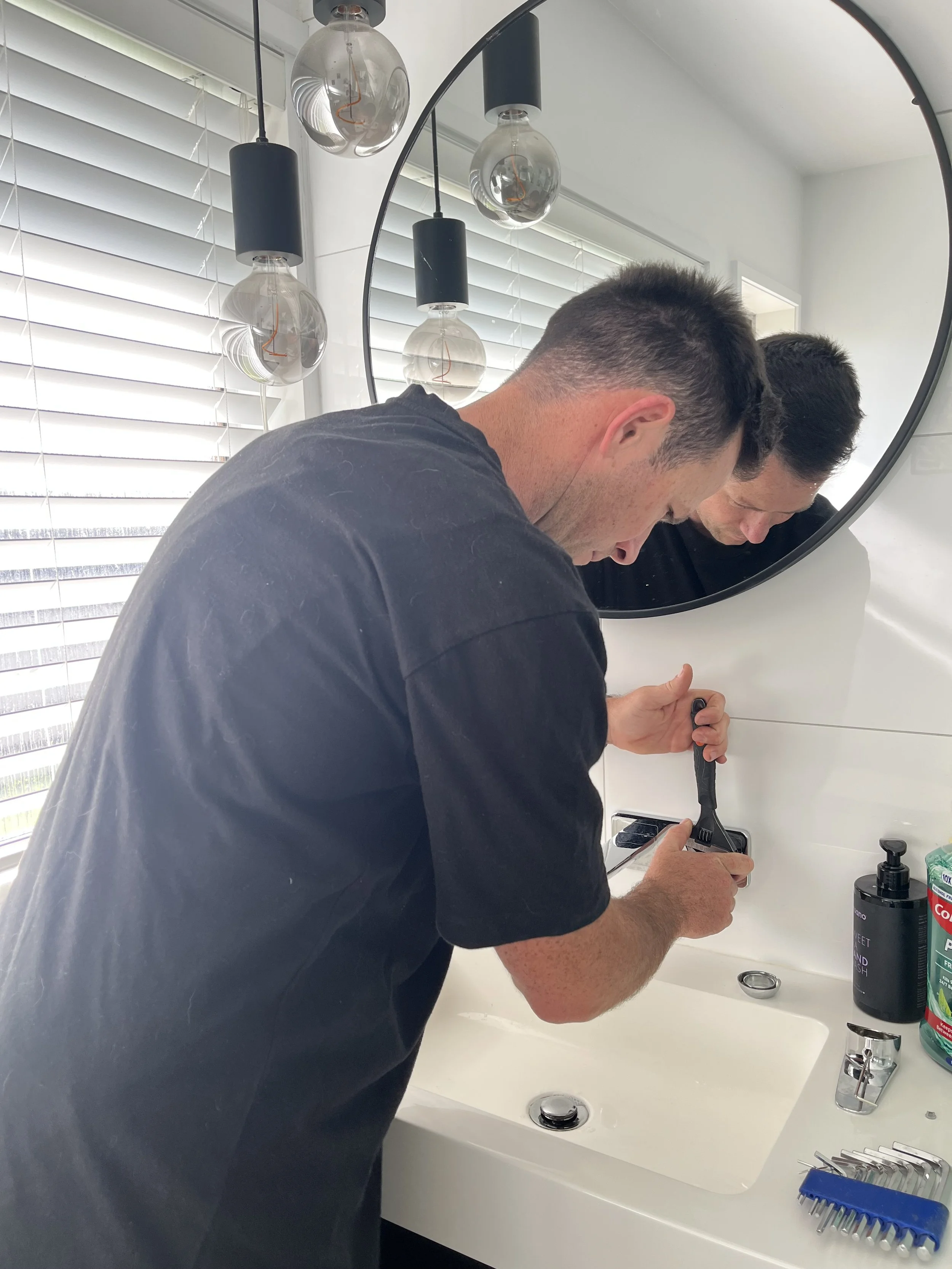 east auckland plumber working on taps and sink