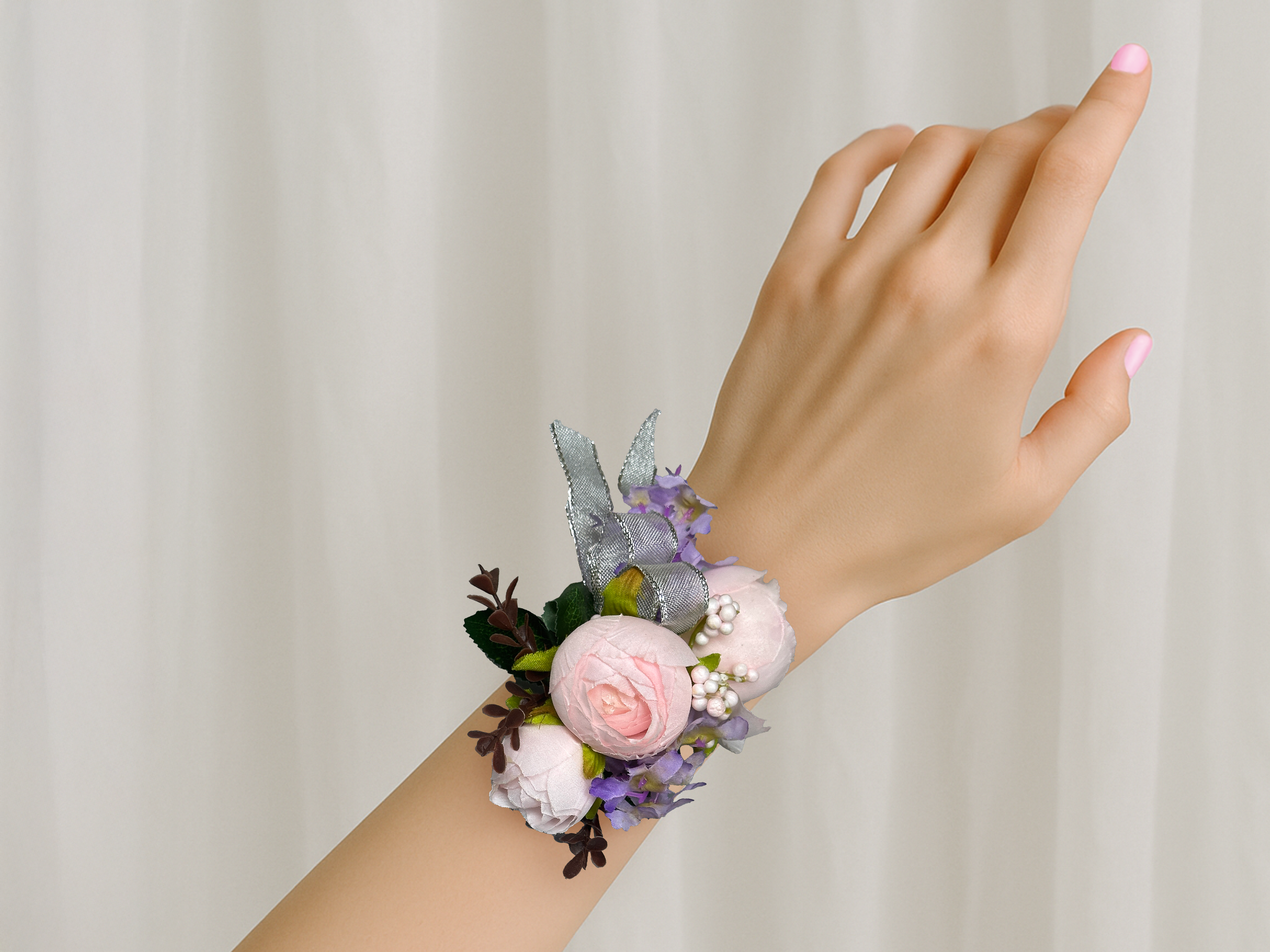 Blush pink and silver corsage on wrist.png