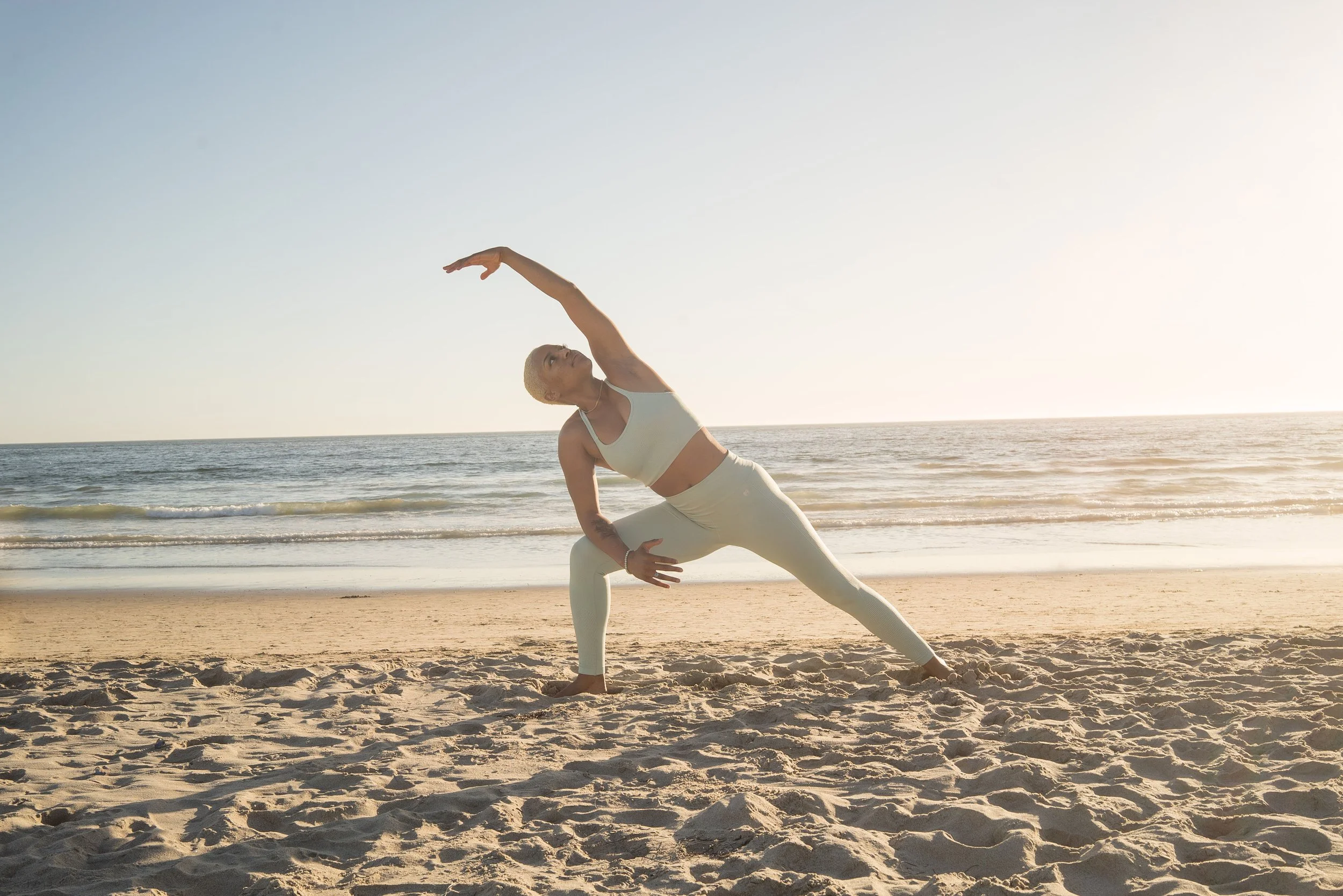 blog author Mya Pearson on beach in lunge with horizon in background