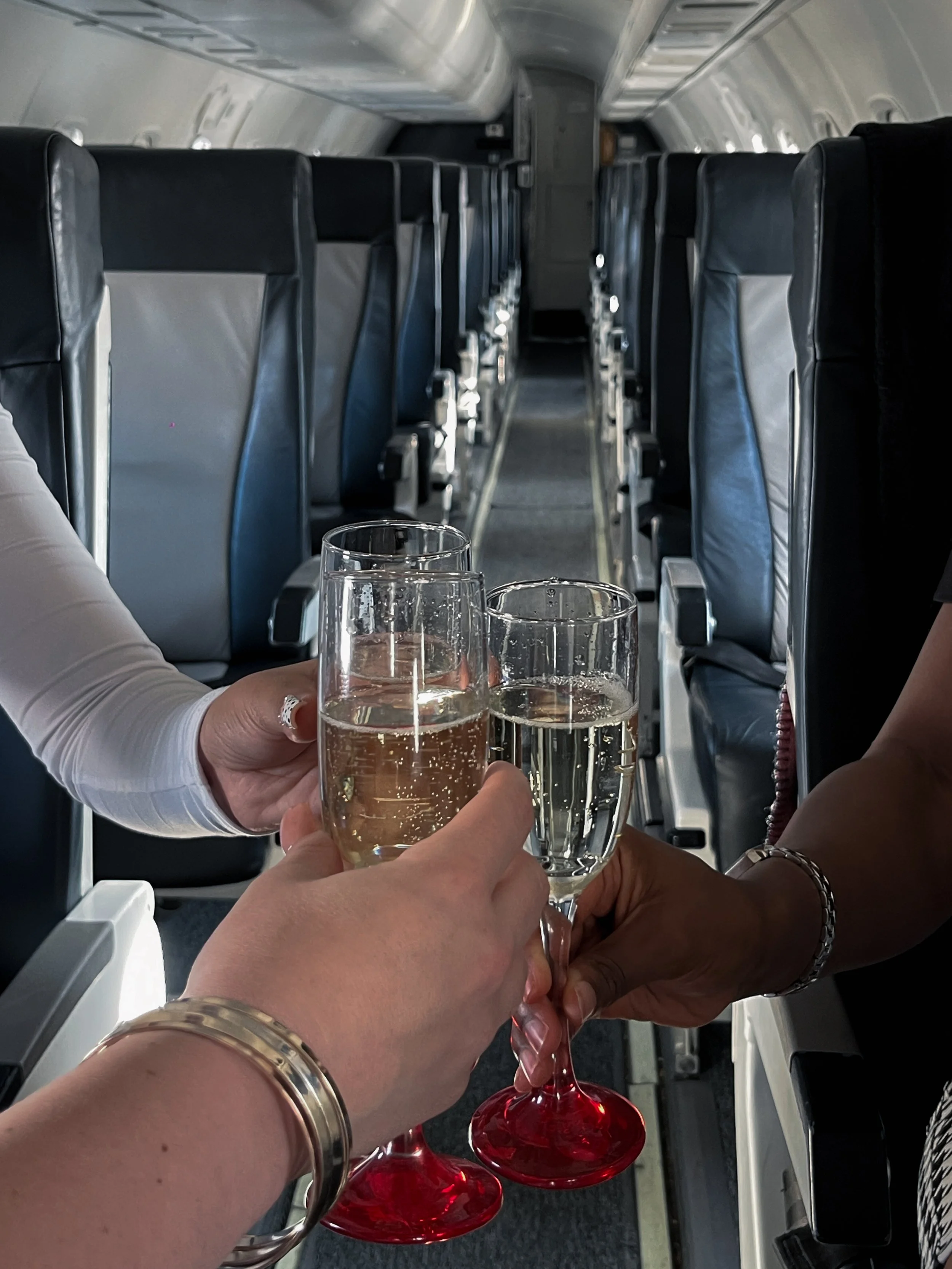 Passengers enjoying champagne inside a private jet, showcasing the luxury and elevated experience of flying with Exodus Aircraft. From premium amenities to personalized service, every flight is designed to deliver comfort and a first-class experienc.