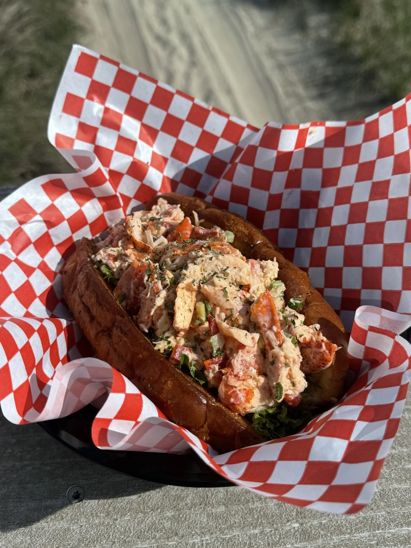 Lobster roll sandwich served on red-and-white checkered paper