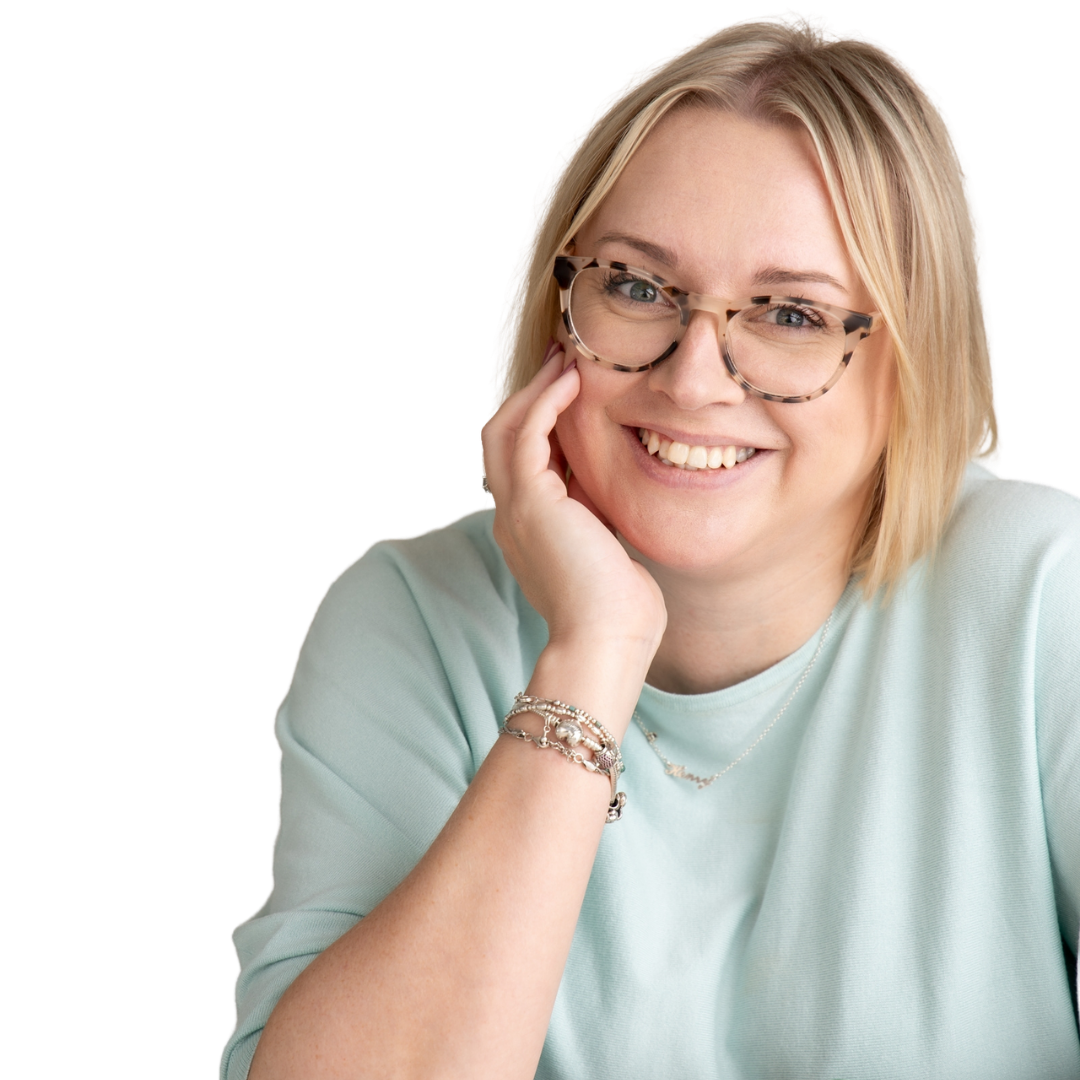 Sadie Finch with blonde hair wearing glasses and light blue top, resting her chin on her hand.
